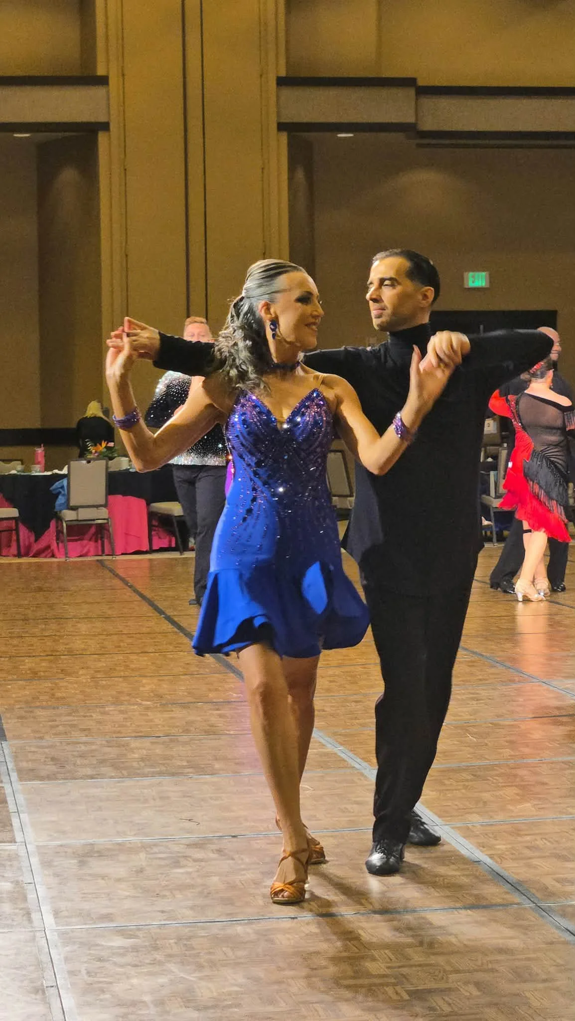 A competition pair in blue and black dances at Hawaii Star Ball
