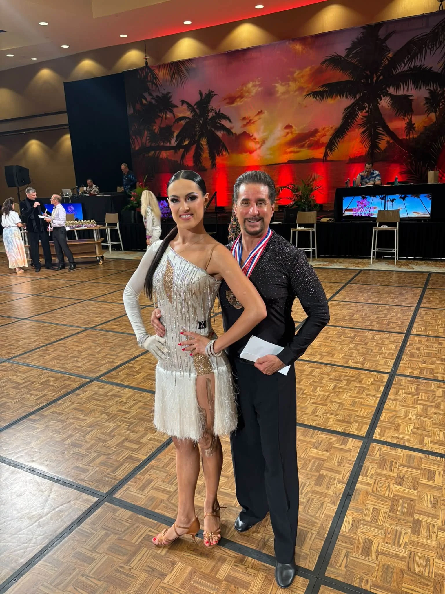 A Dance Fire competition pair poses beside the Hawaii Star Ball floor
