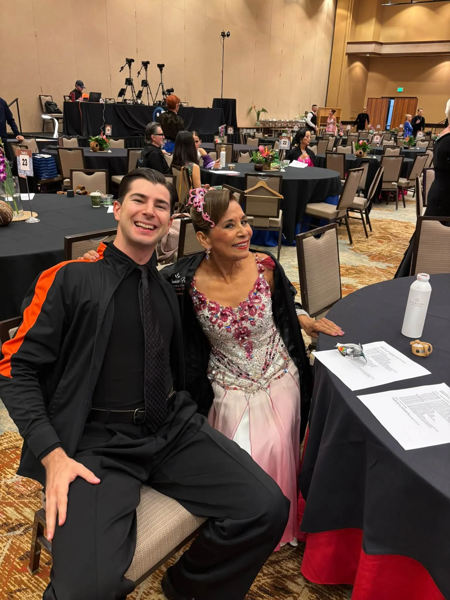 A Dance Fire competition pair sits together between their dances