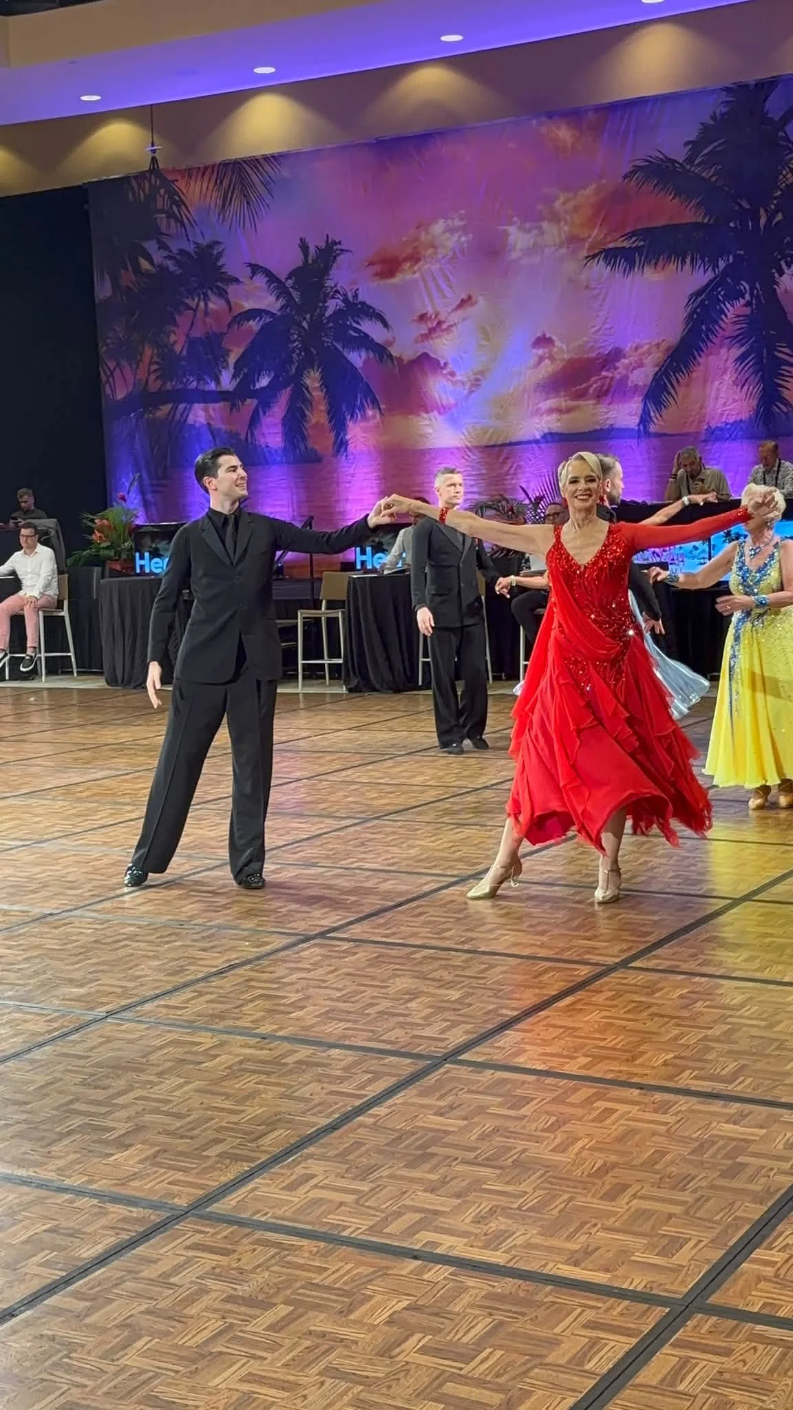 A competition couple in red and black dances at Hawaii Star Ball