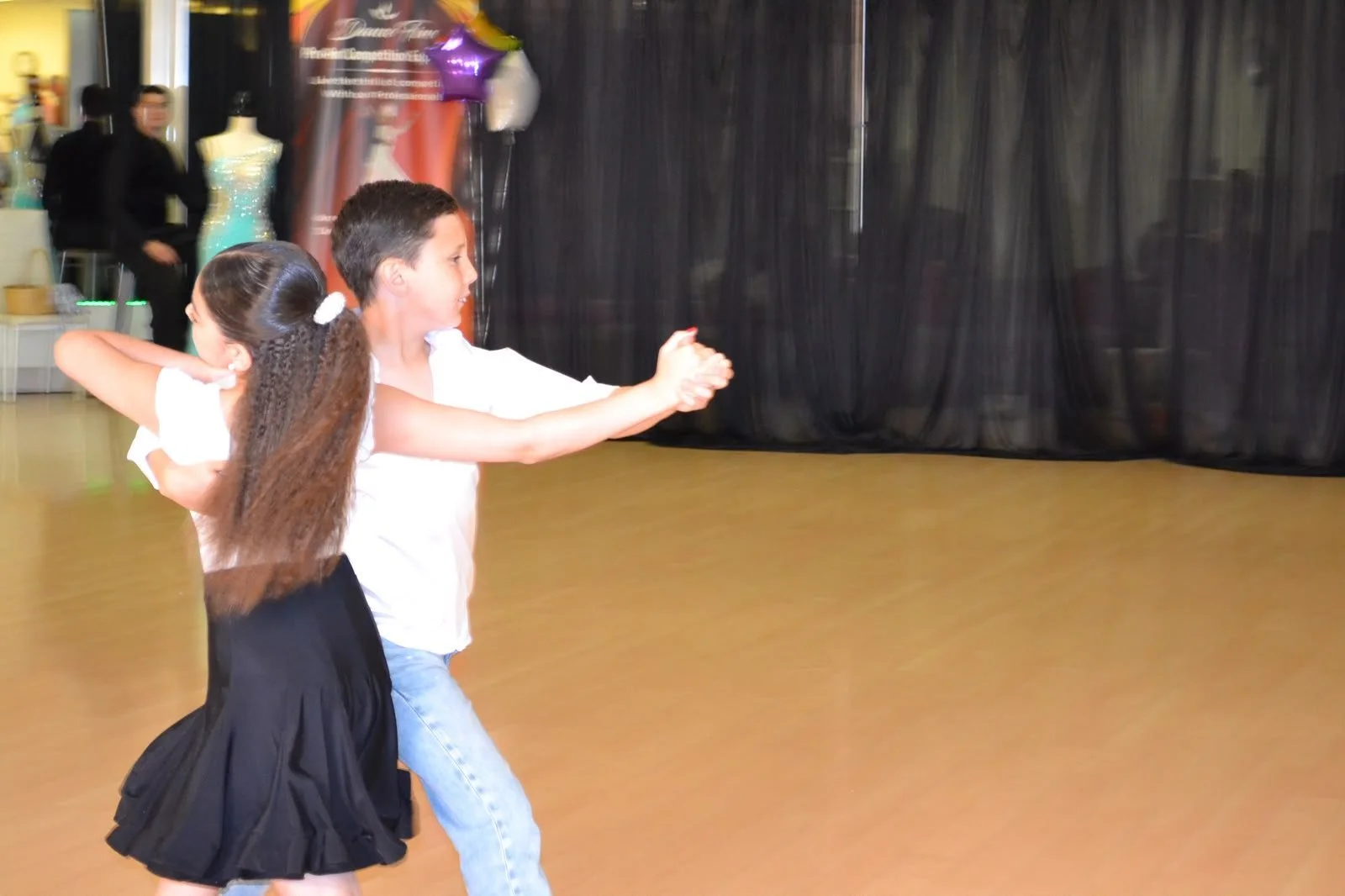 A young dance couple performs in hold during the spring recital