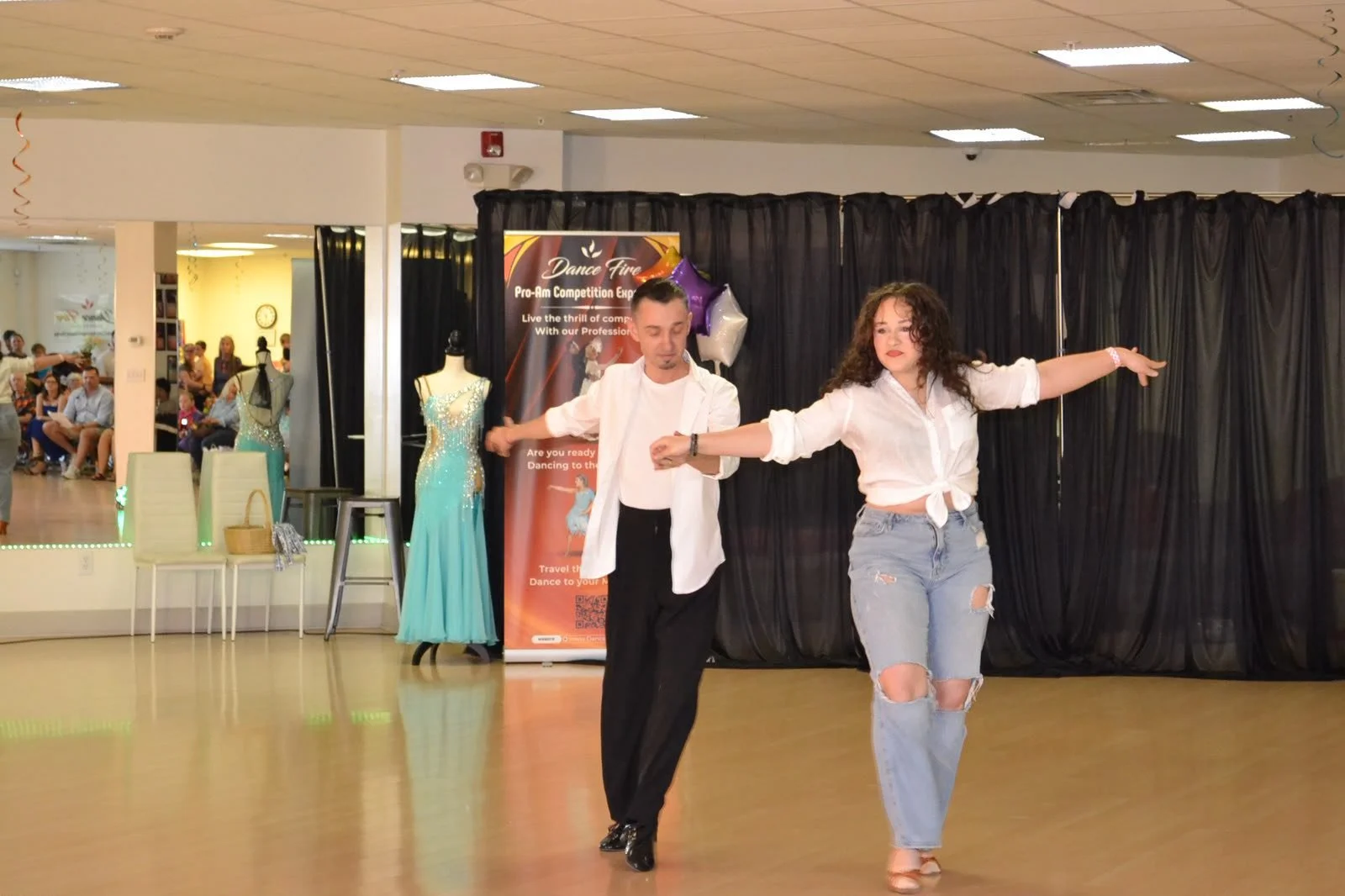 Two young performers extend their arms during a recital routine