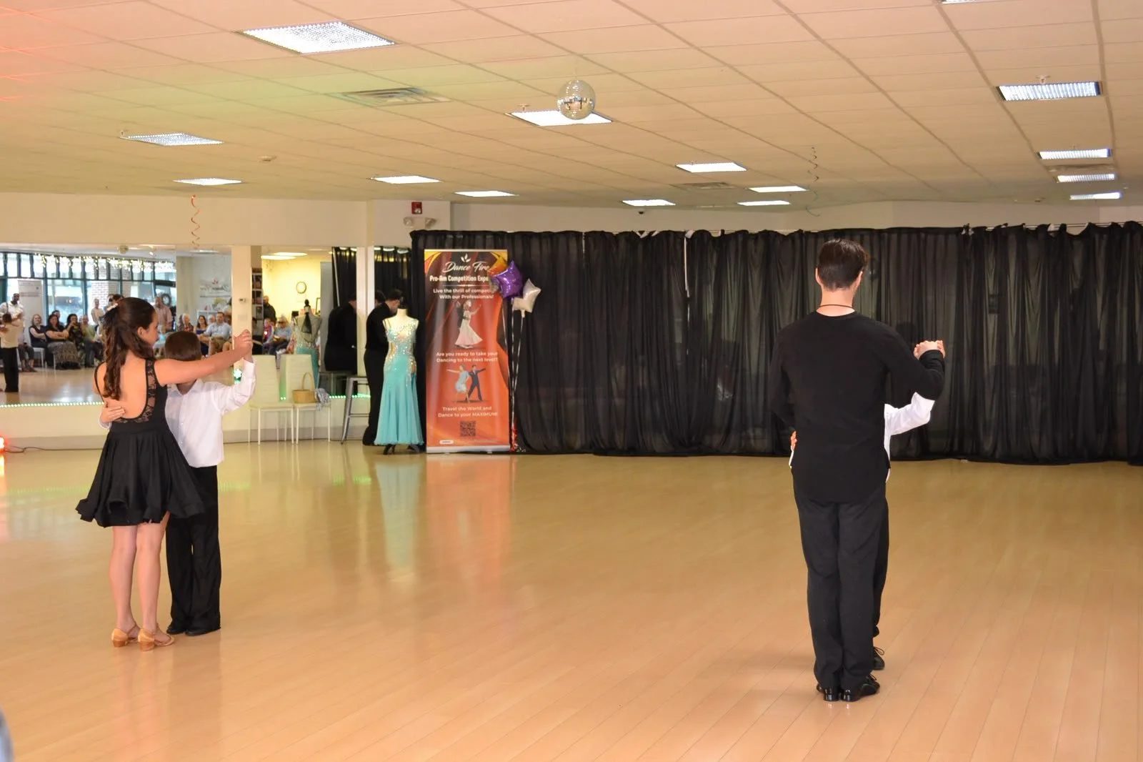 A young dancer and instructor perform across the recital floor