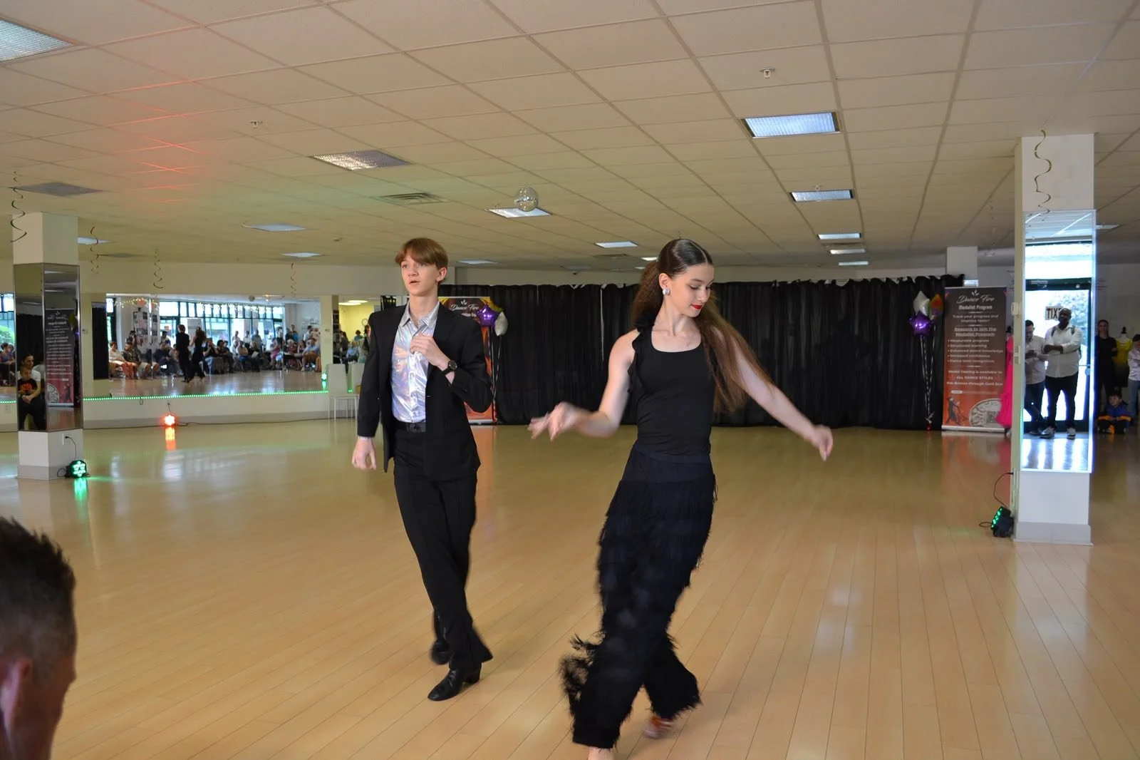 A youth dance couple steps together during a partnered routine