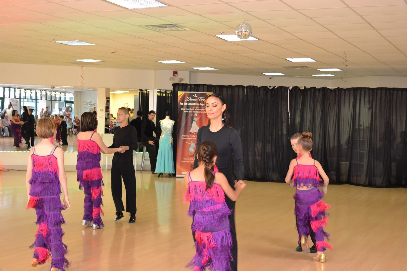 Children in purple costumes follow a group recital formation