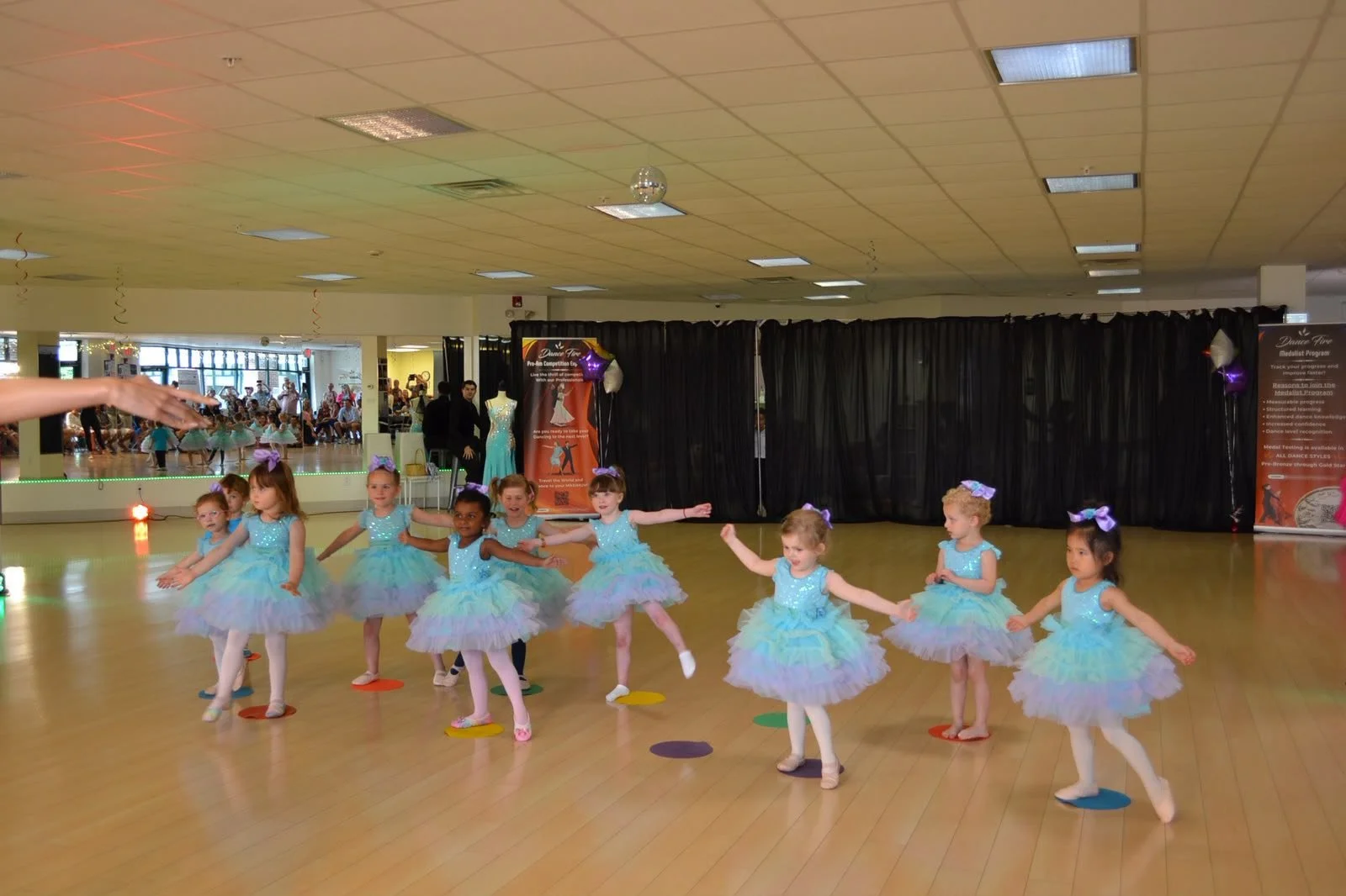 Young ballet dancers perform together in pastel tutus