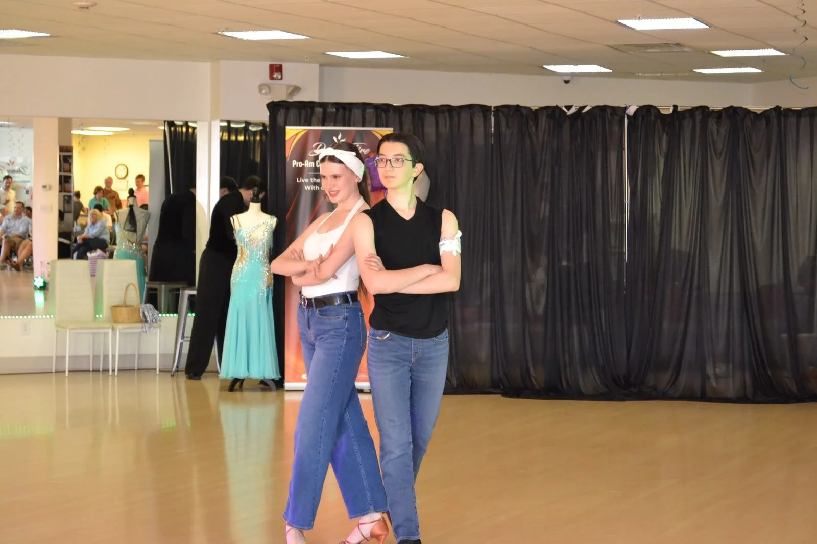 Two young performers dance together in dark tops and blue trousers