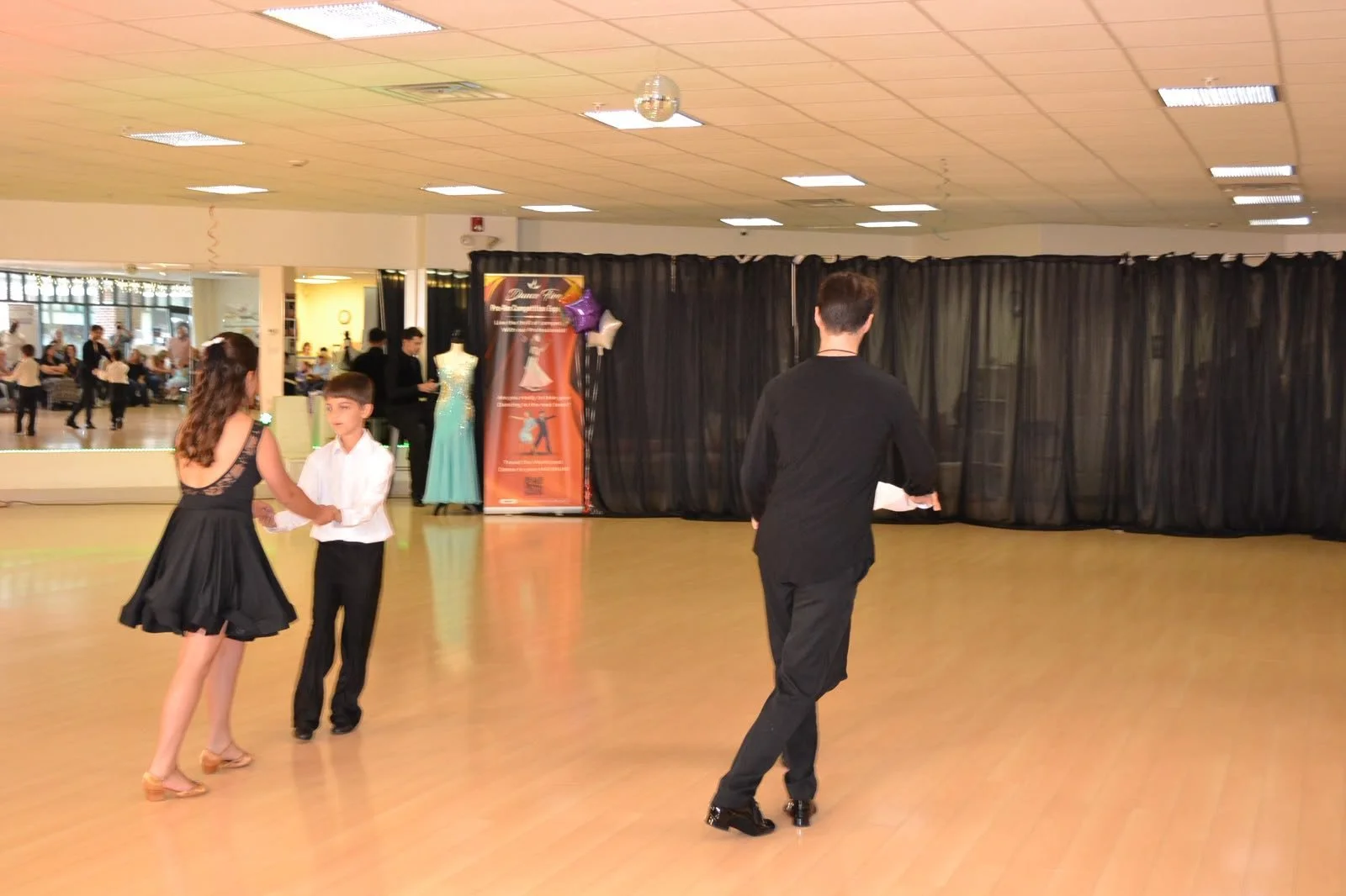 An instructor demonstrates movement beside young recital performers