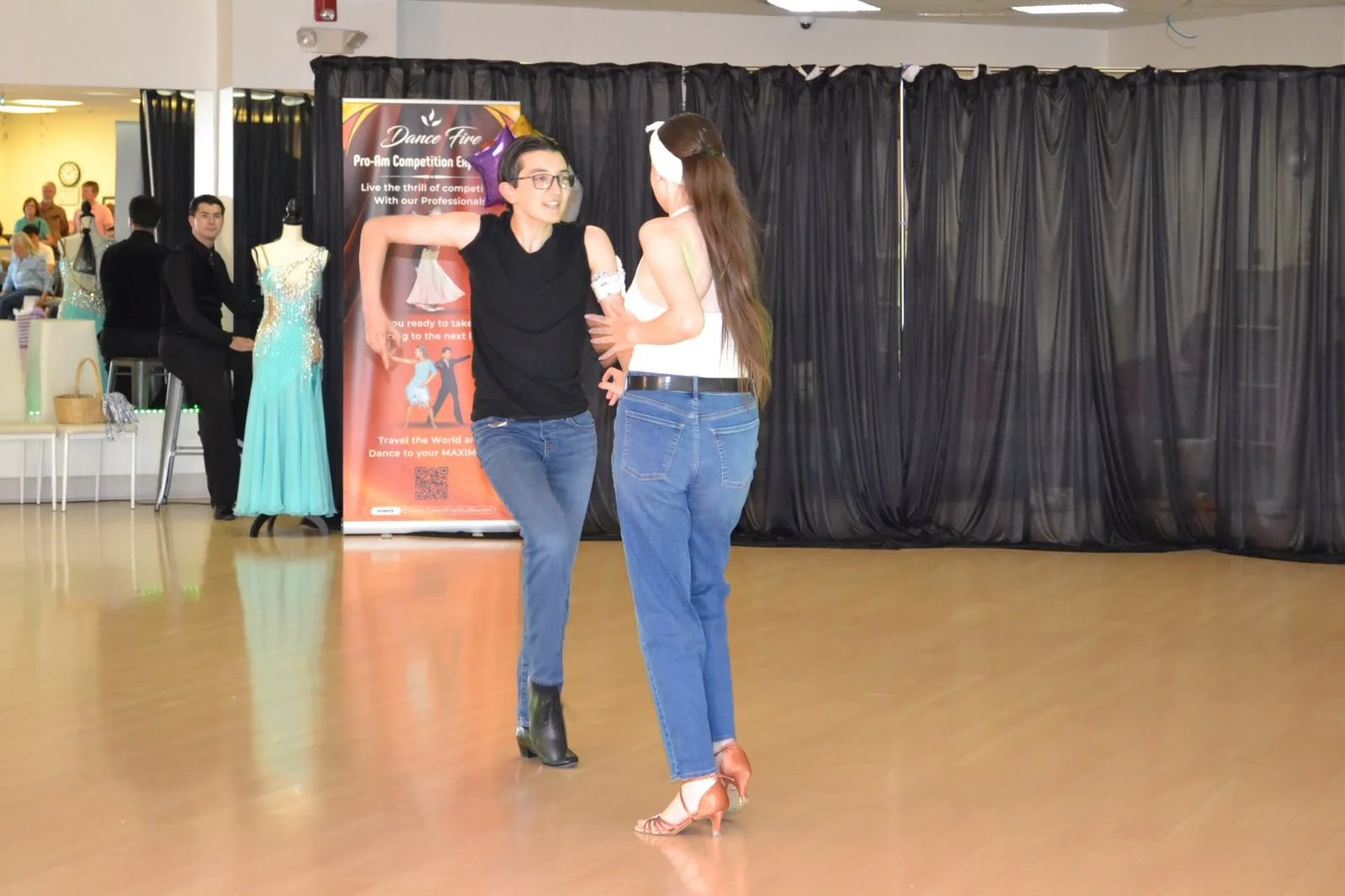 Two young dancers in jeans perform side by side at the recital