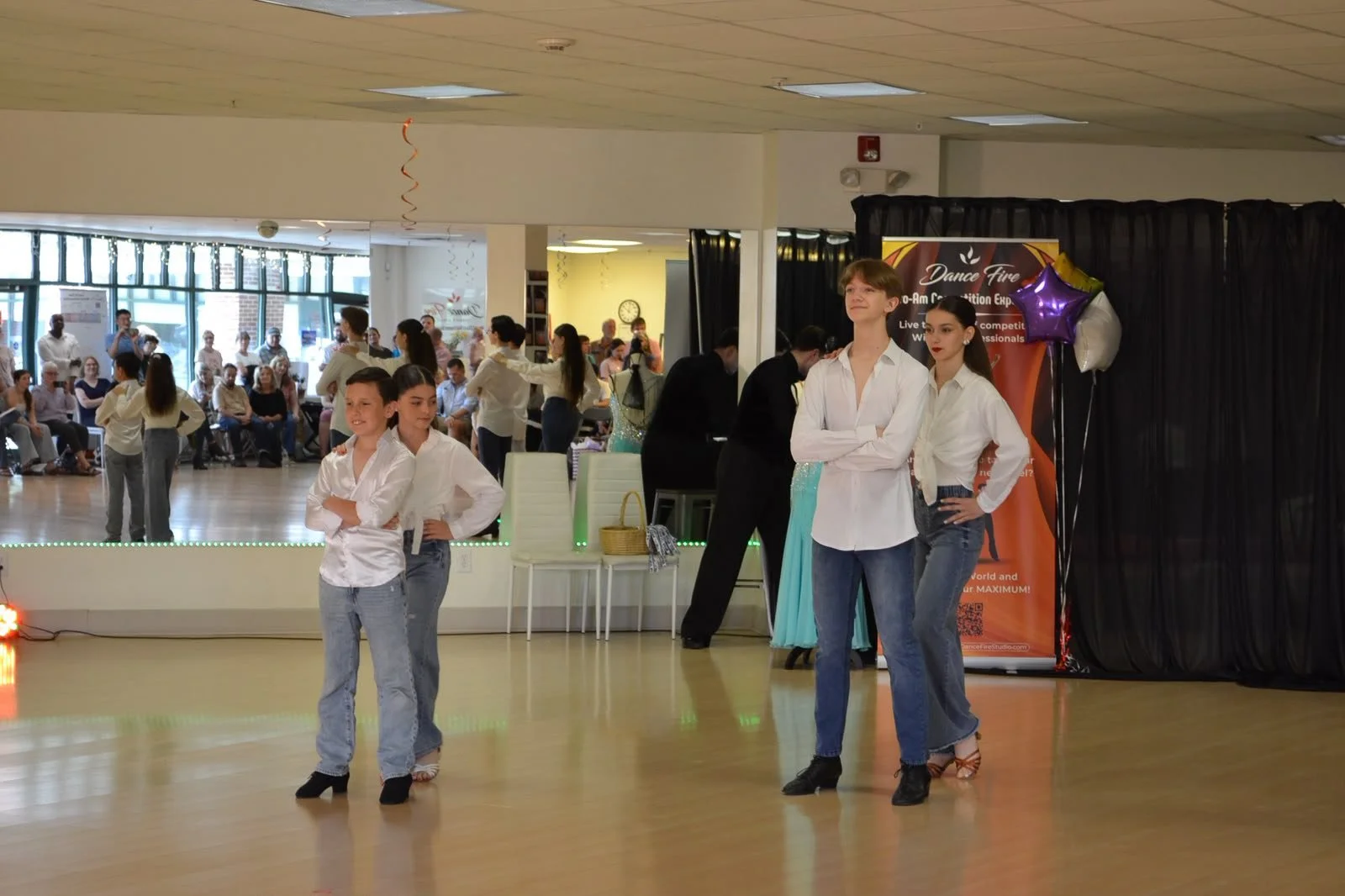 Youth performers in white shirts and jeans dance together