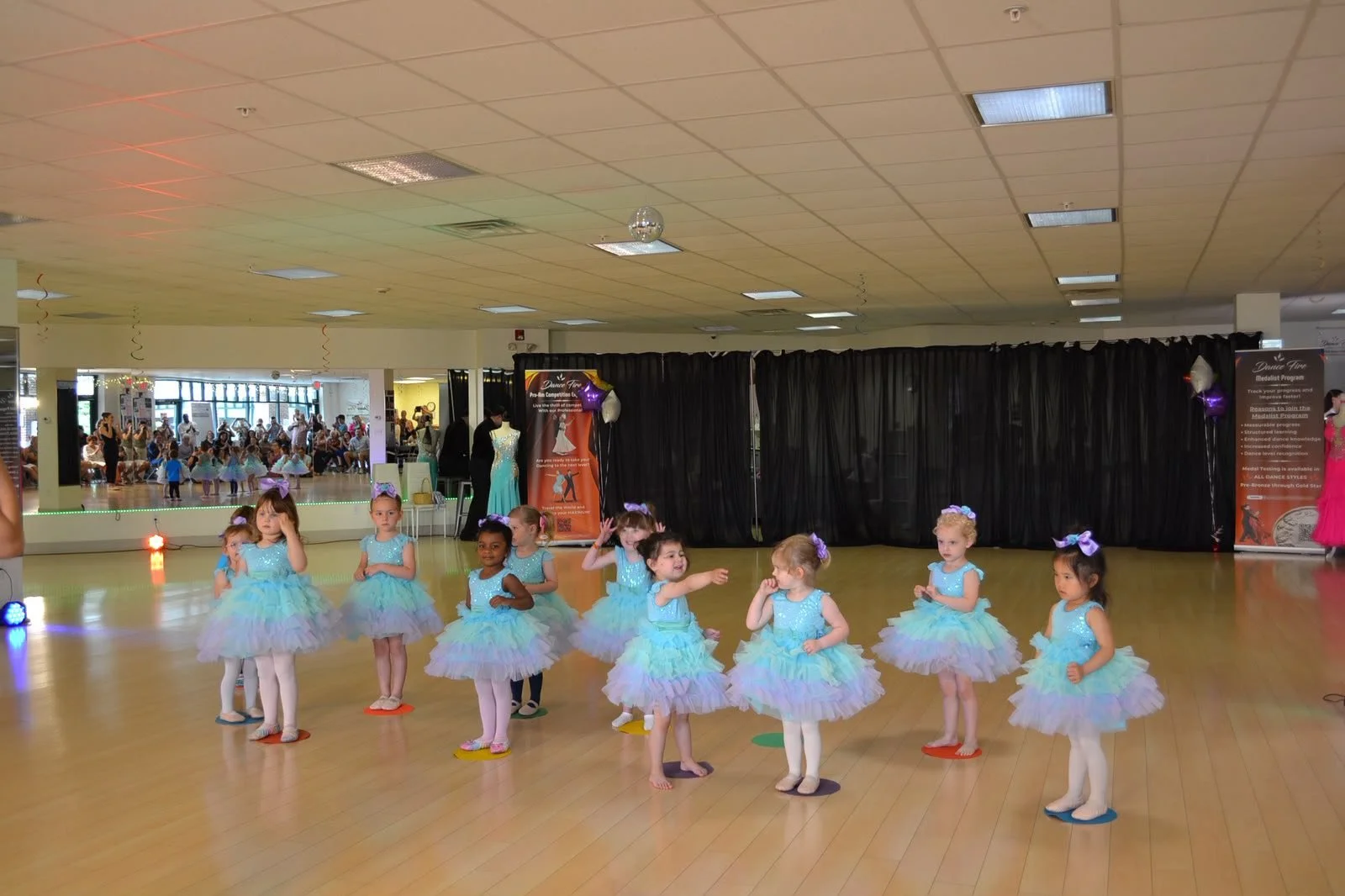 Young ballet dancers perform in a line of pastel tutus