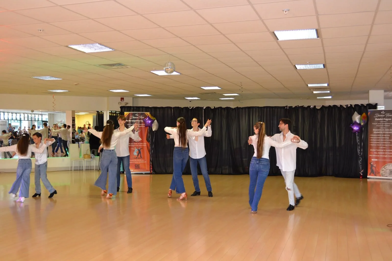 Youth dancers extend their arms in a coordinated recital formation