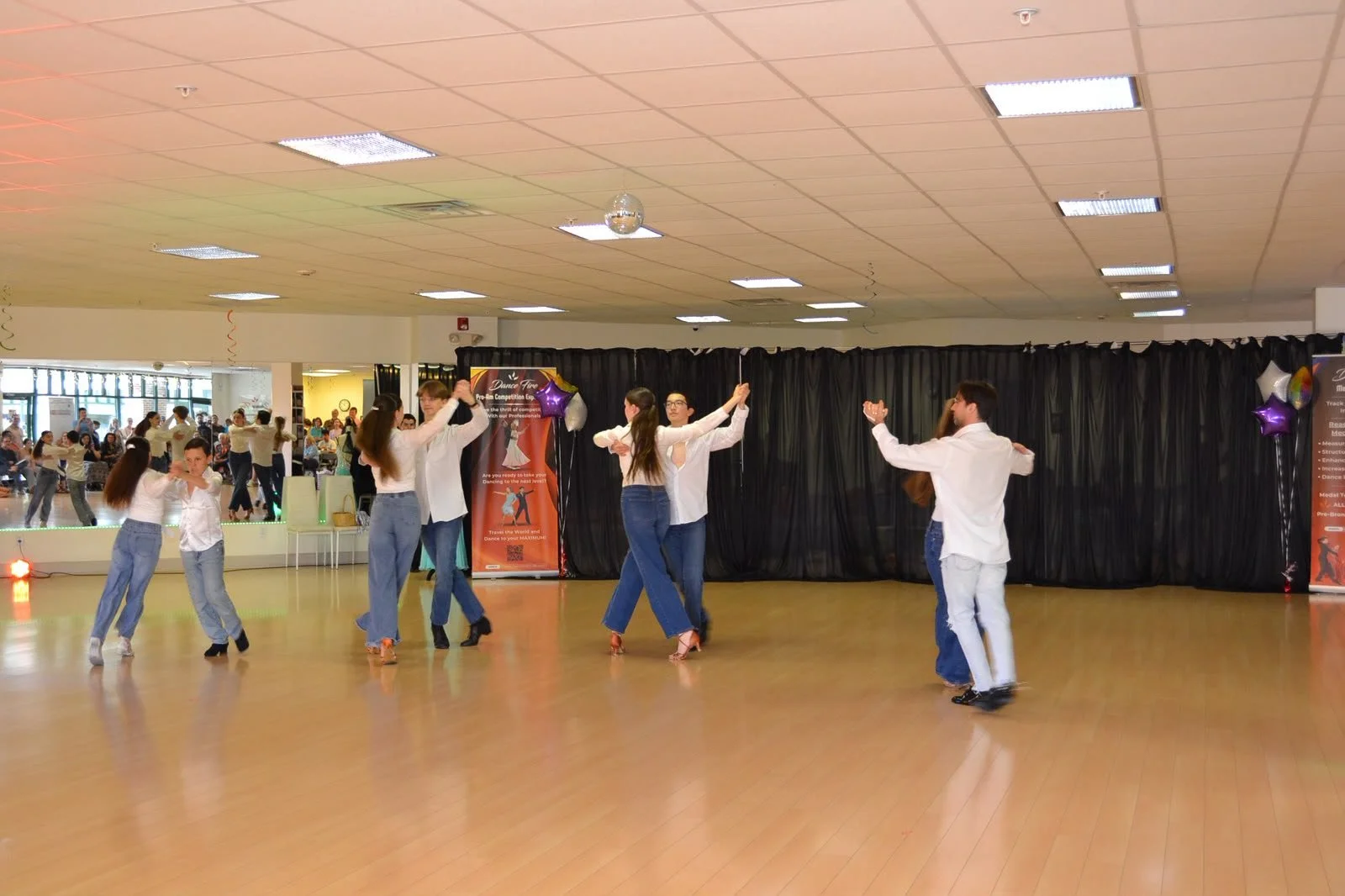 Young performers extend their arms across the studio in a group routine