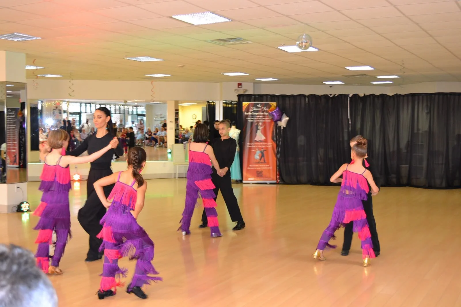 Children in purple costumes move through a coordinated recital routine