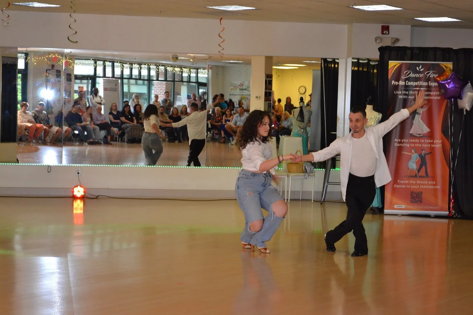 Youth dancers perform an extended-arm group movement