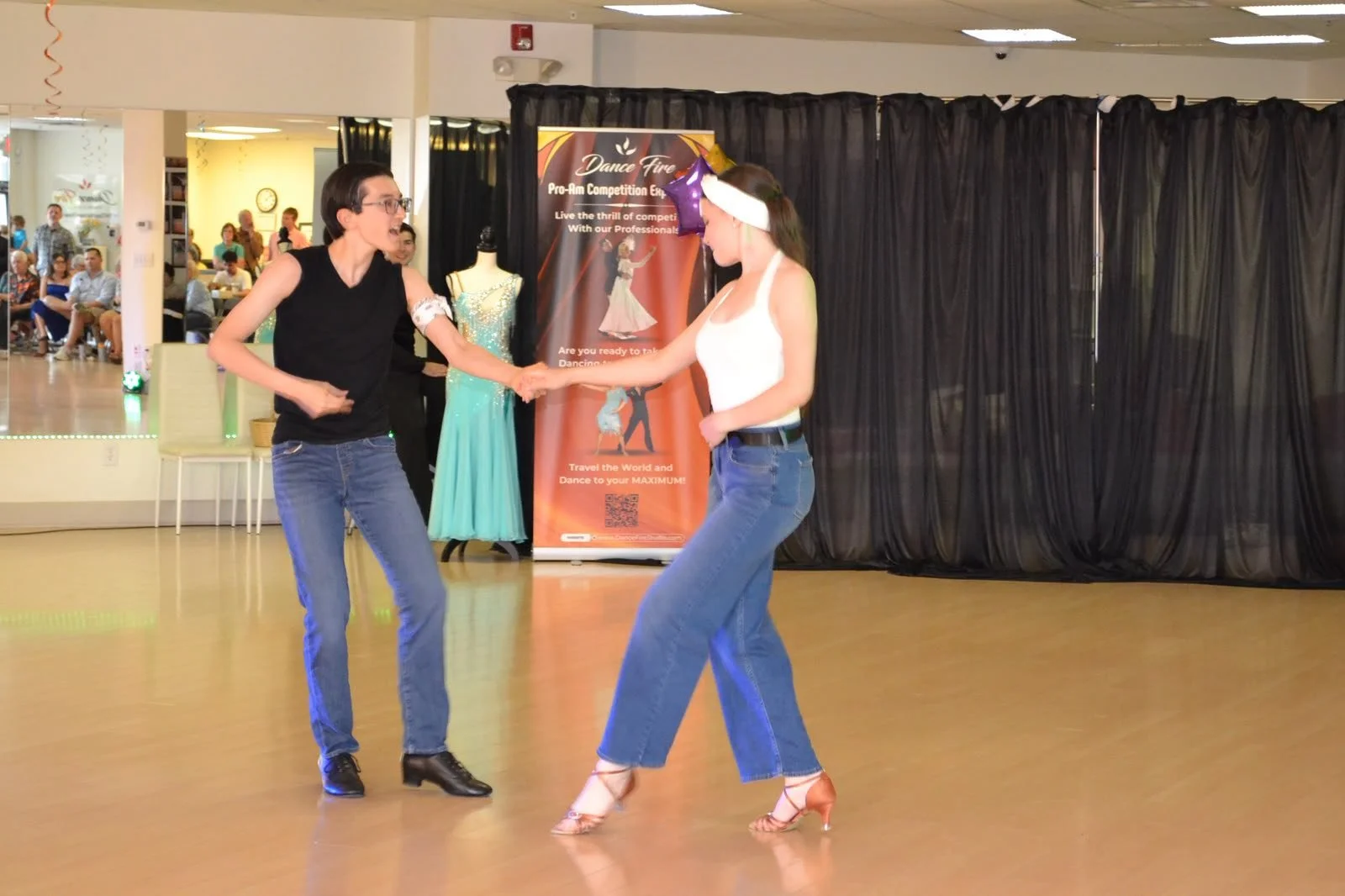 Two young performers dance together in dark tops and blue trousers