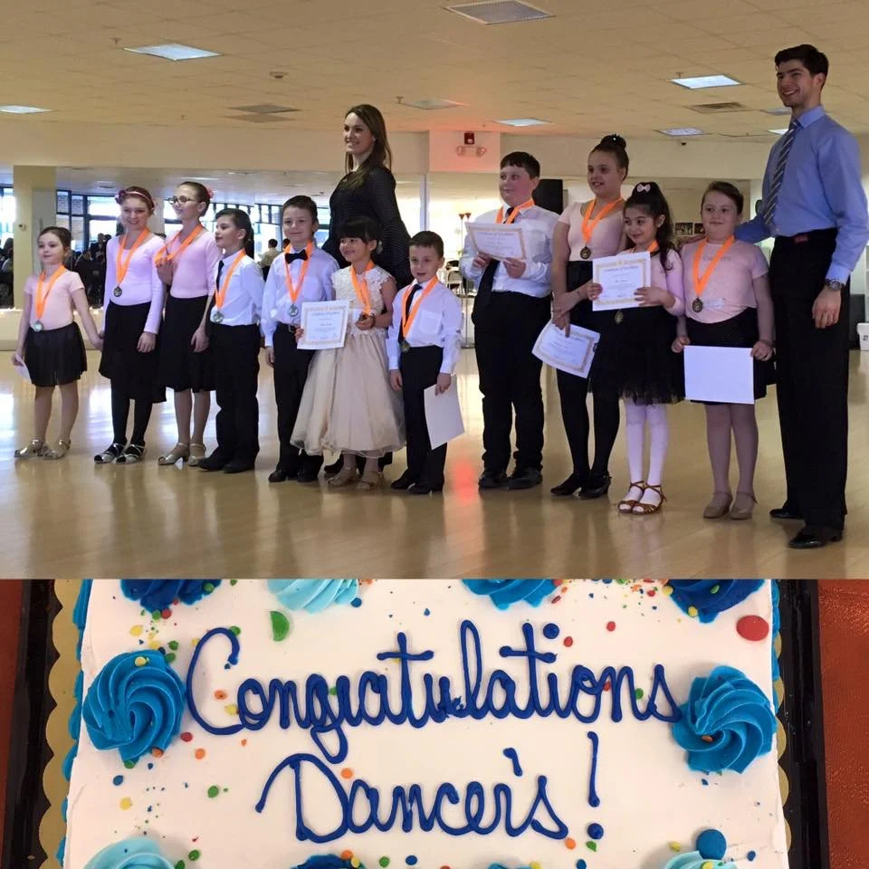 Young recital dancers display their awards above a cake reading Congratulations Dancers