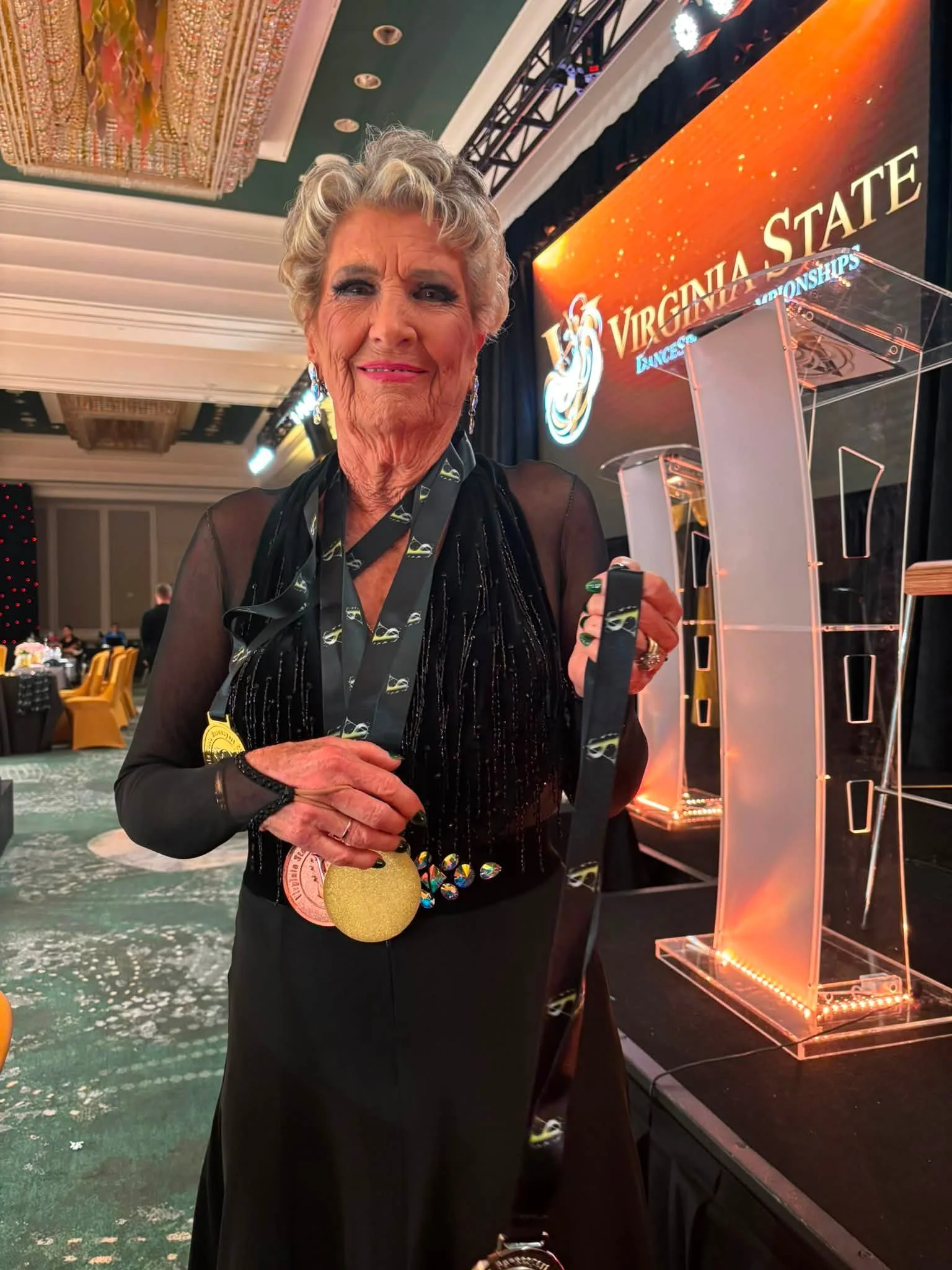 A Dance Fire student displays a medal at Virginia DanceSport