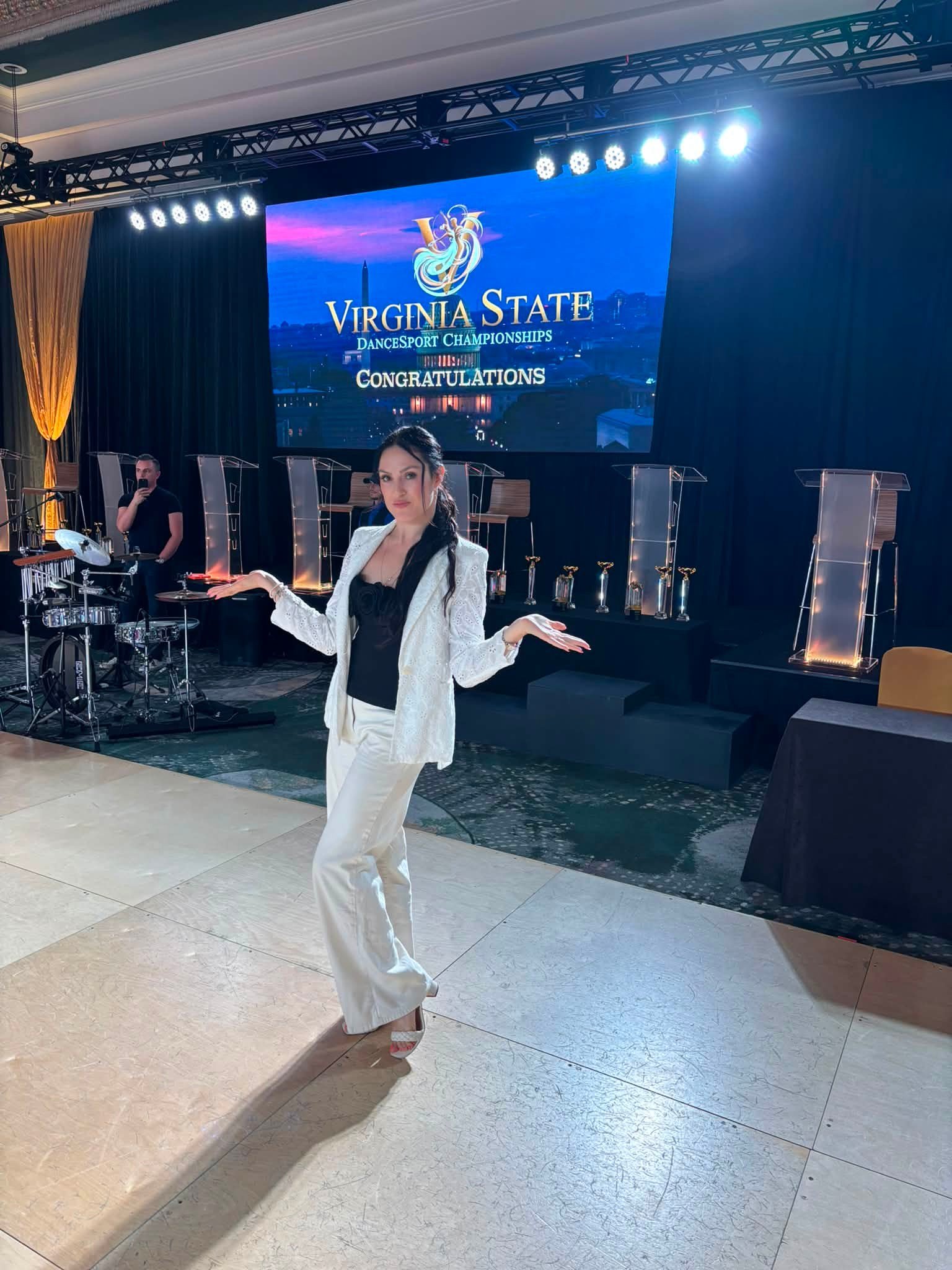 A dancer in white performs beside the Virginia championship display