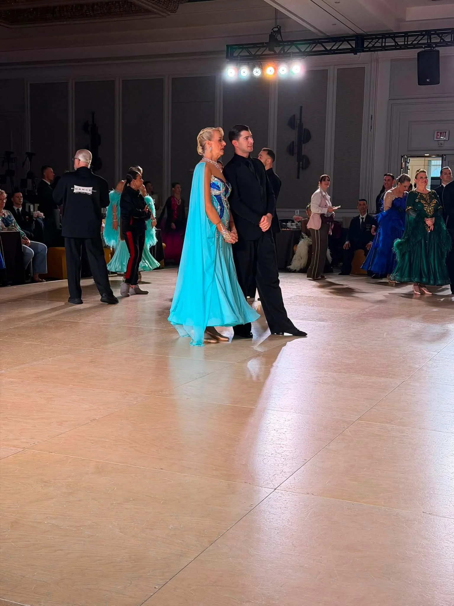 A couple performs a ballroom routine in turquoise and black at Virginia DanceSport
