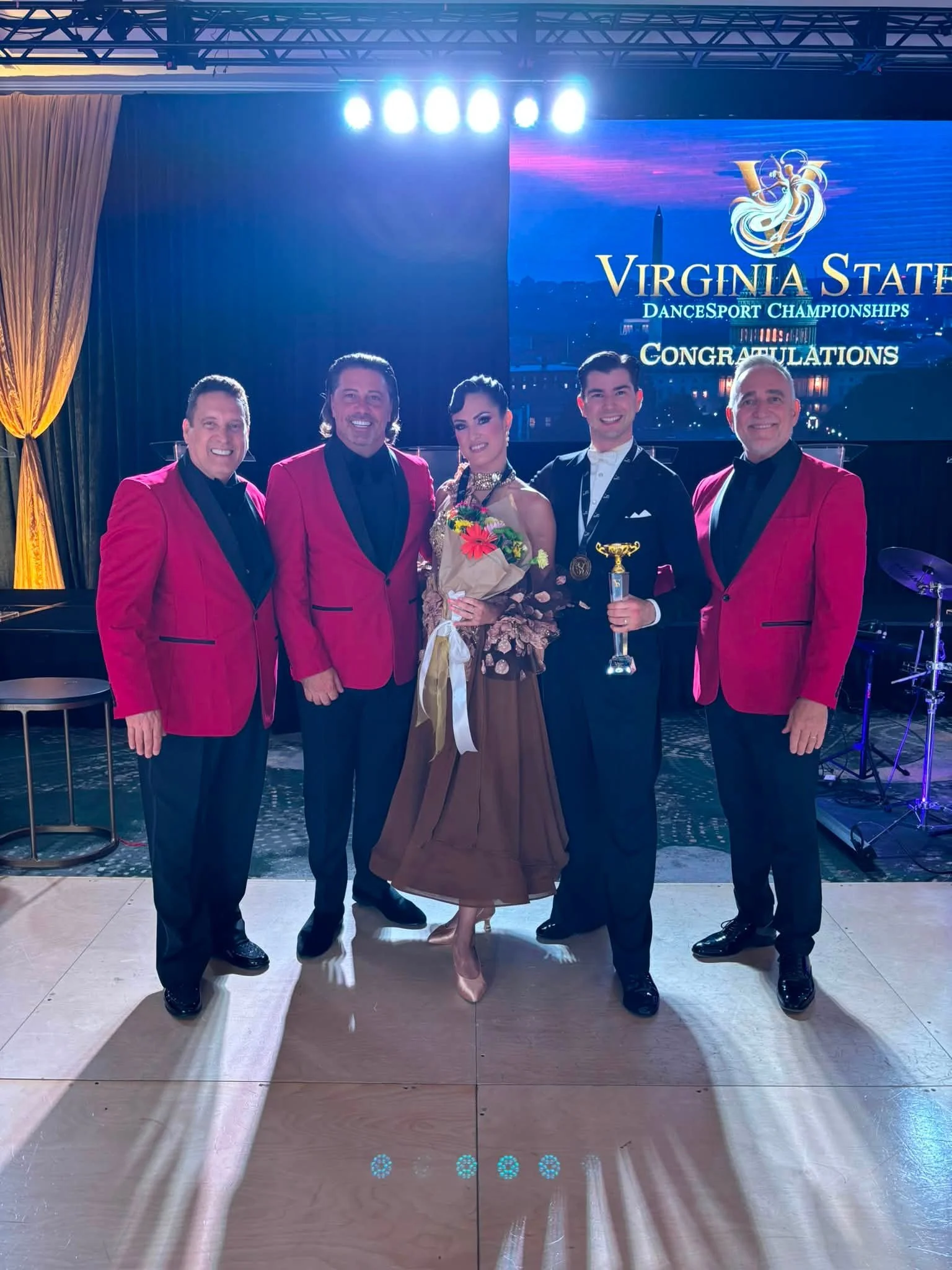 Event participants pose together beneath the Virginia championship display