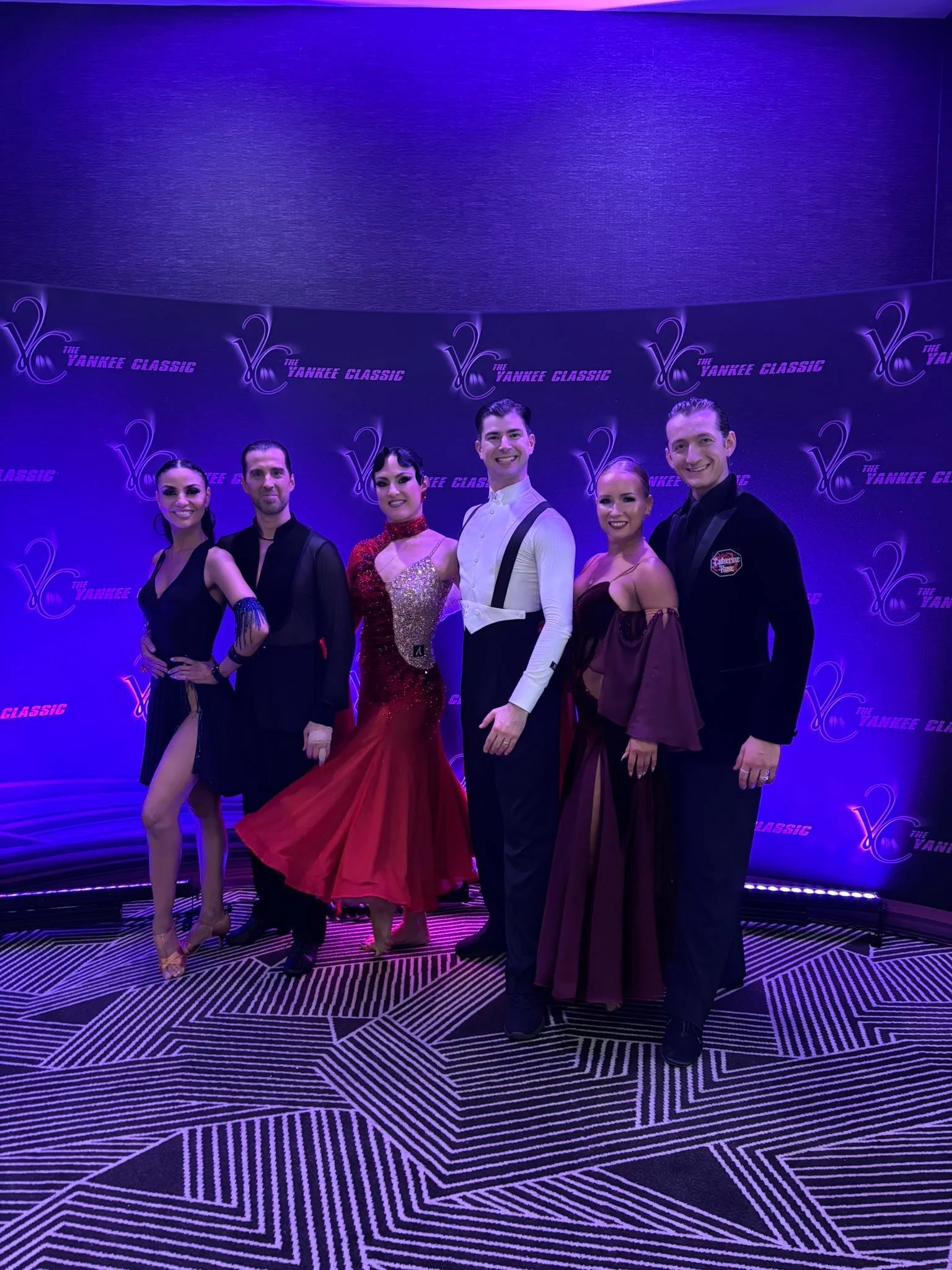 Dance Fire dancers pose together at the Yankee Classic event backdrop
