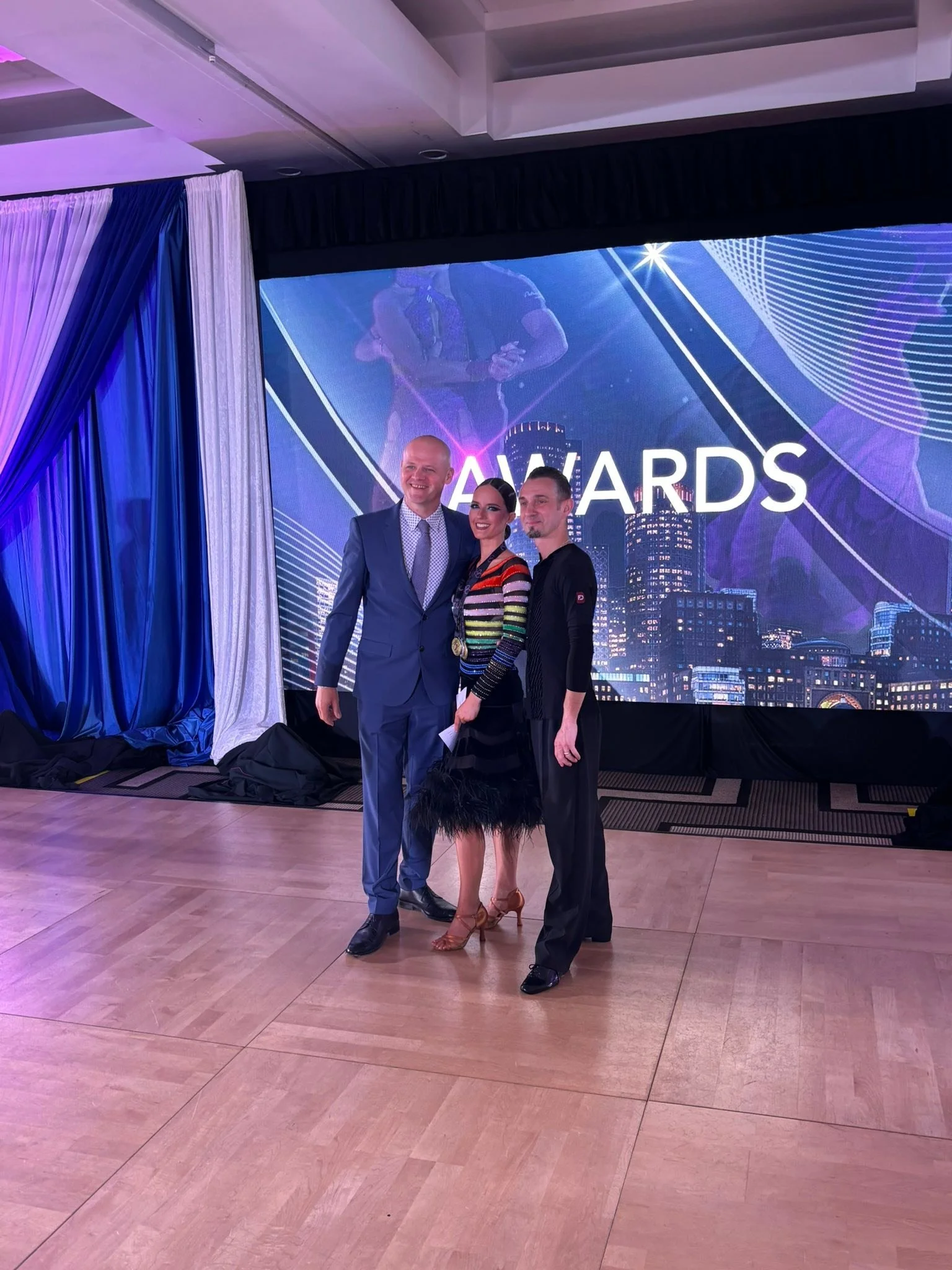 A youth dance couple stands at the Yankee Classic awards display