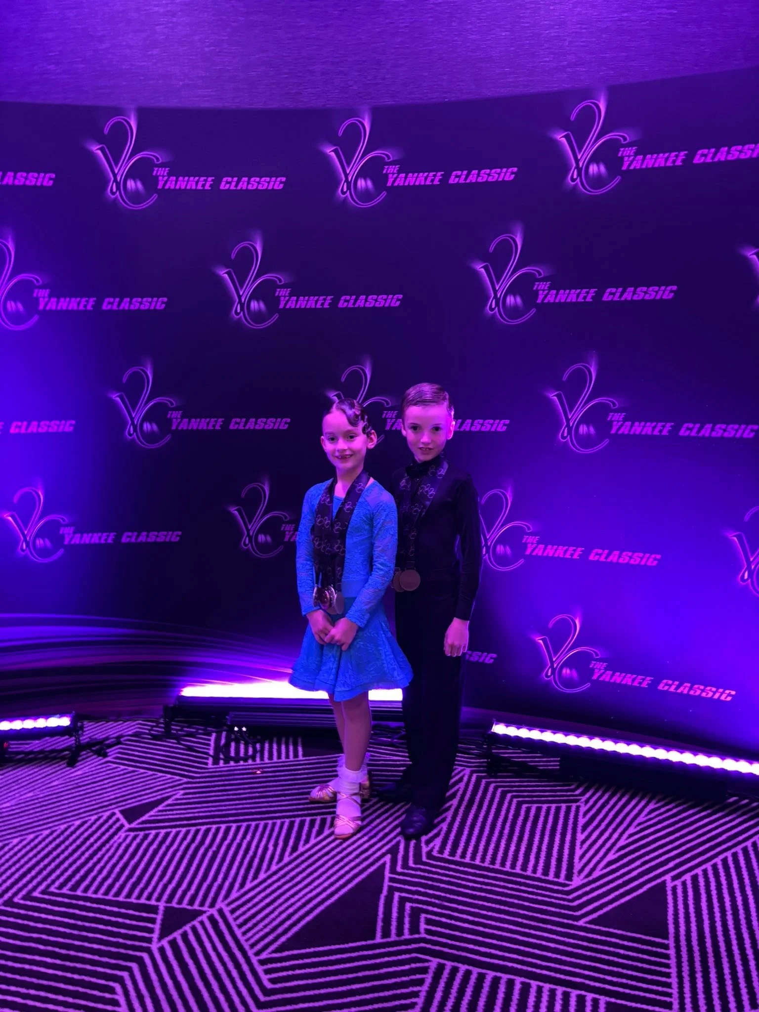 Youth dancers pose together at the Yankee Classic backdrop