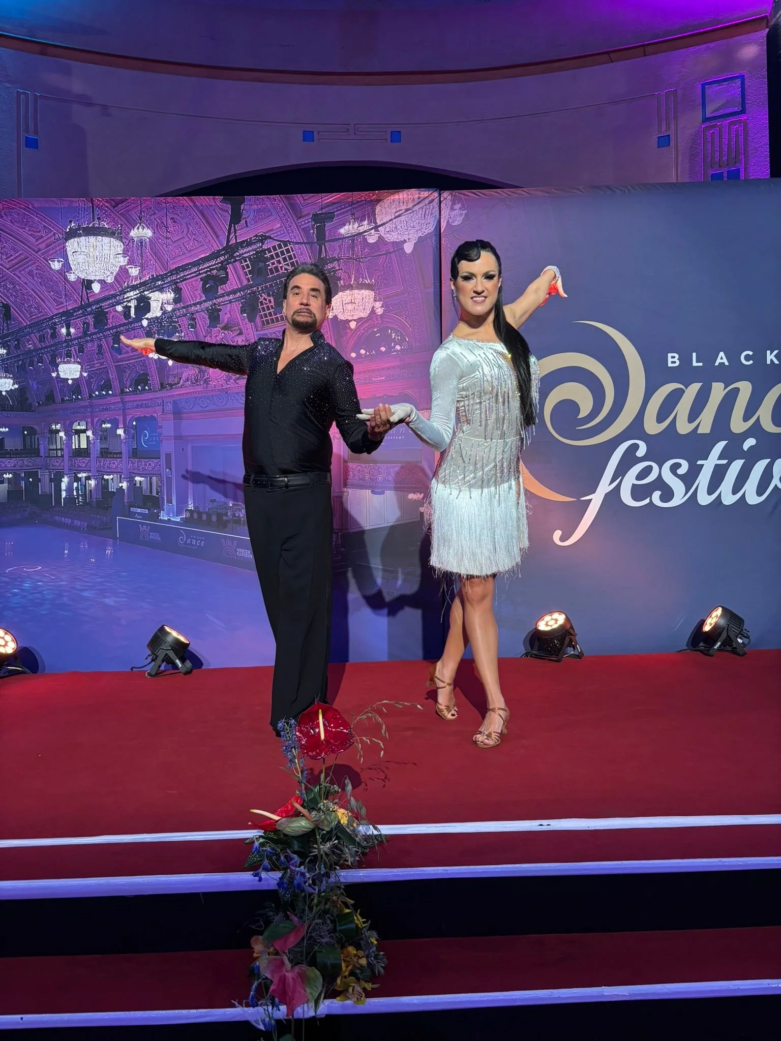 A Dance Fire pair stands on the Blackpool Dance Festival presentation stage