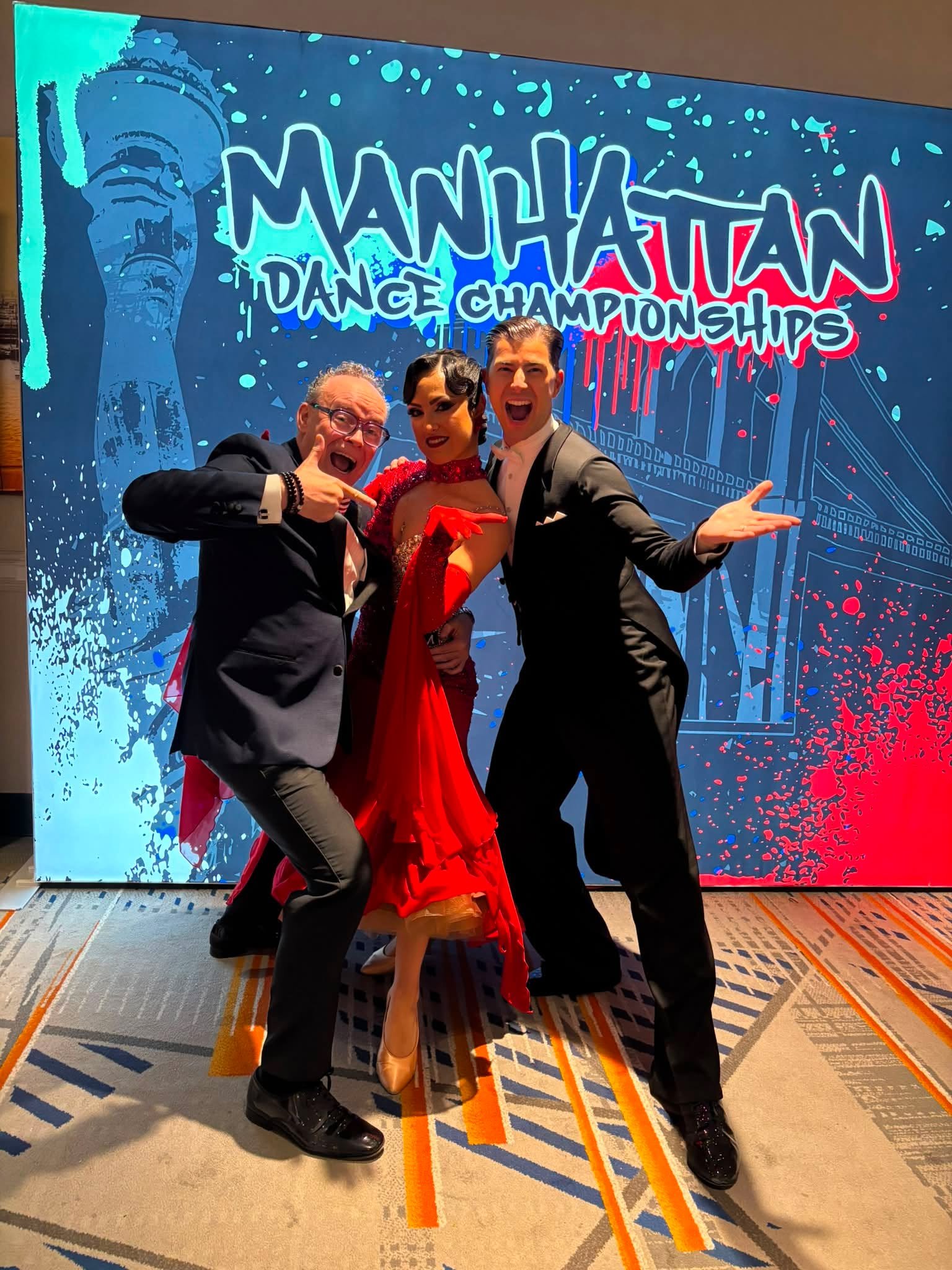 Dance Fire dancers pose at the Manhattan DanceSport Championship backdrop