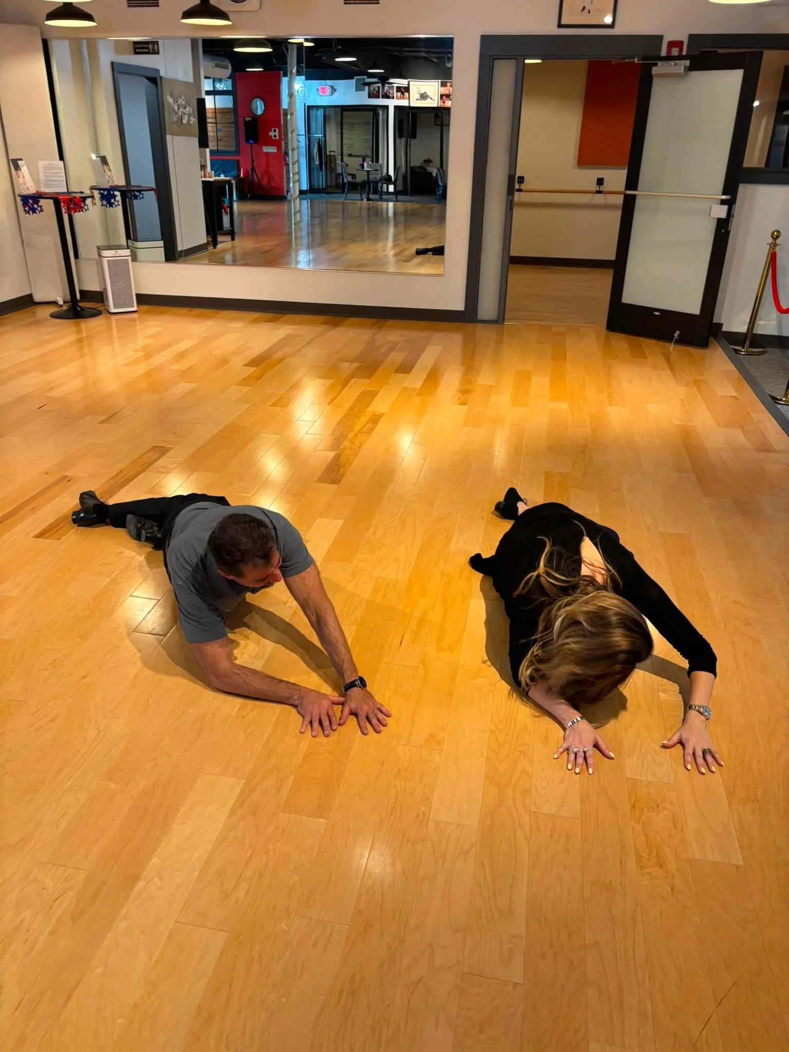 Coaching participants stretch on the Dance Fire studio floor