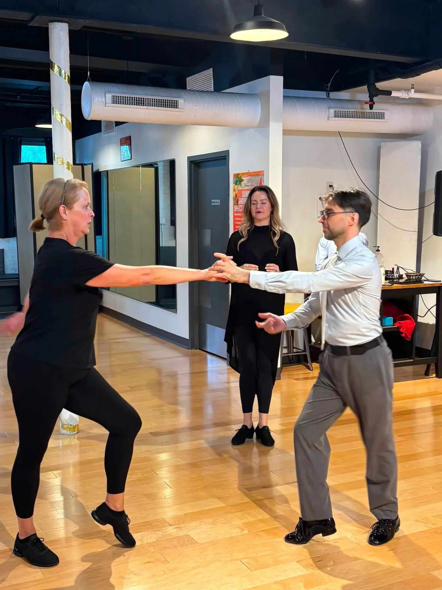 Dancers practice an extended arm position during studio coaching