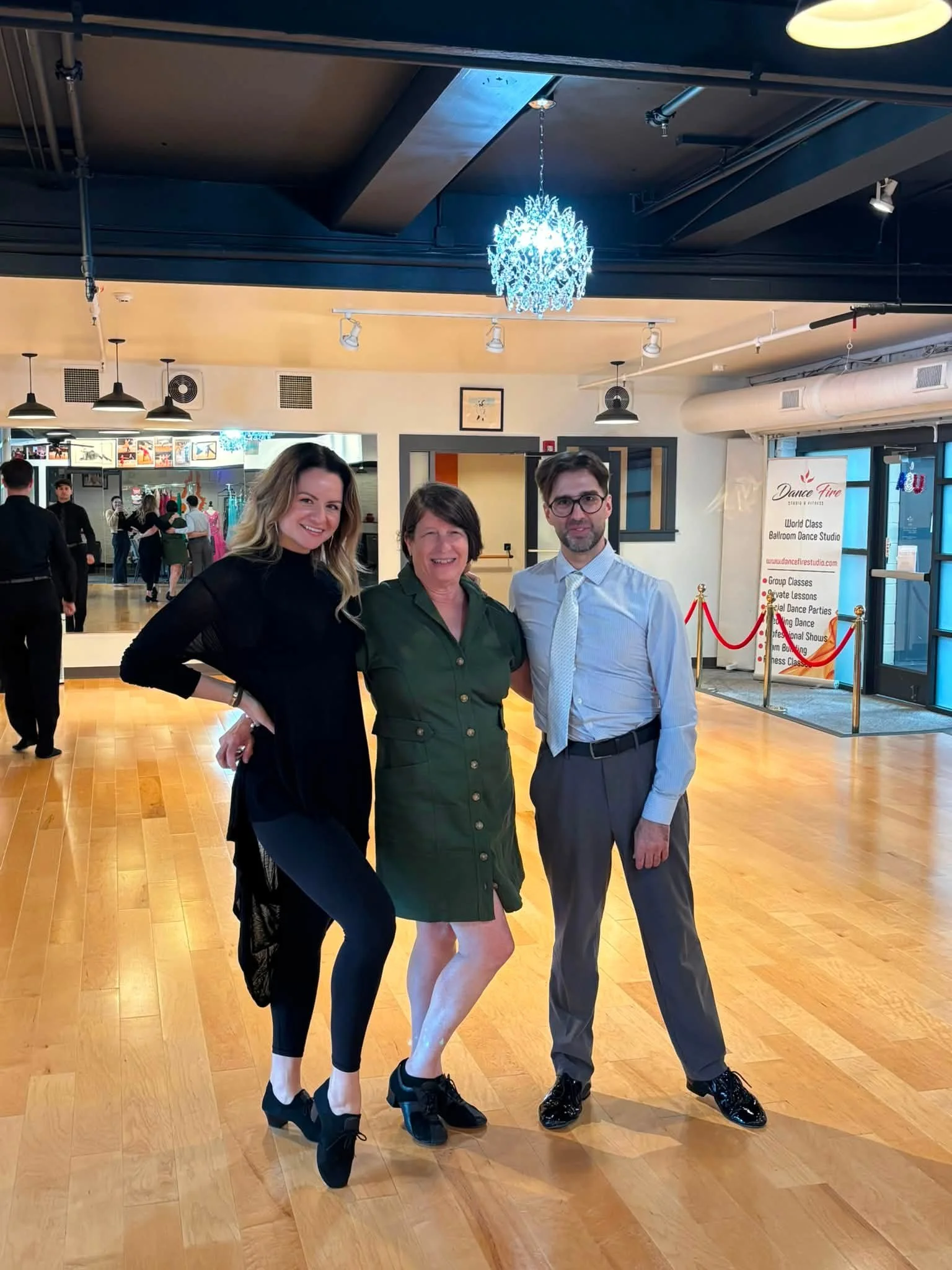 Three coaching participants pose together beside the Dance Fire floor