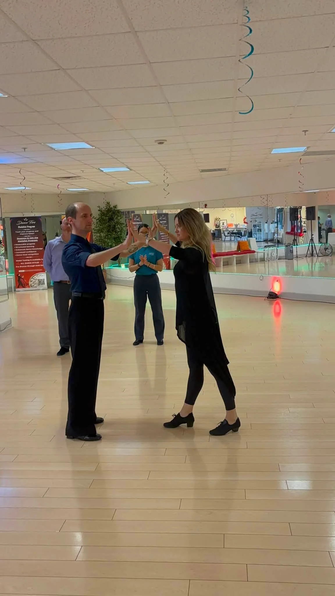 A couple works on partnered dance position during the master class