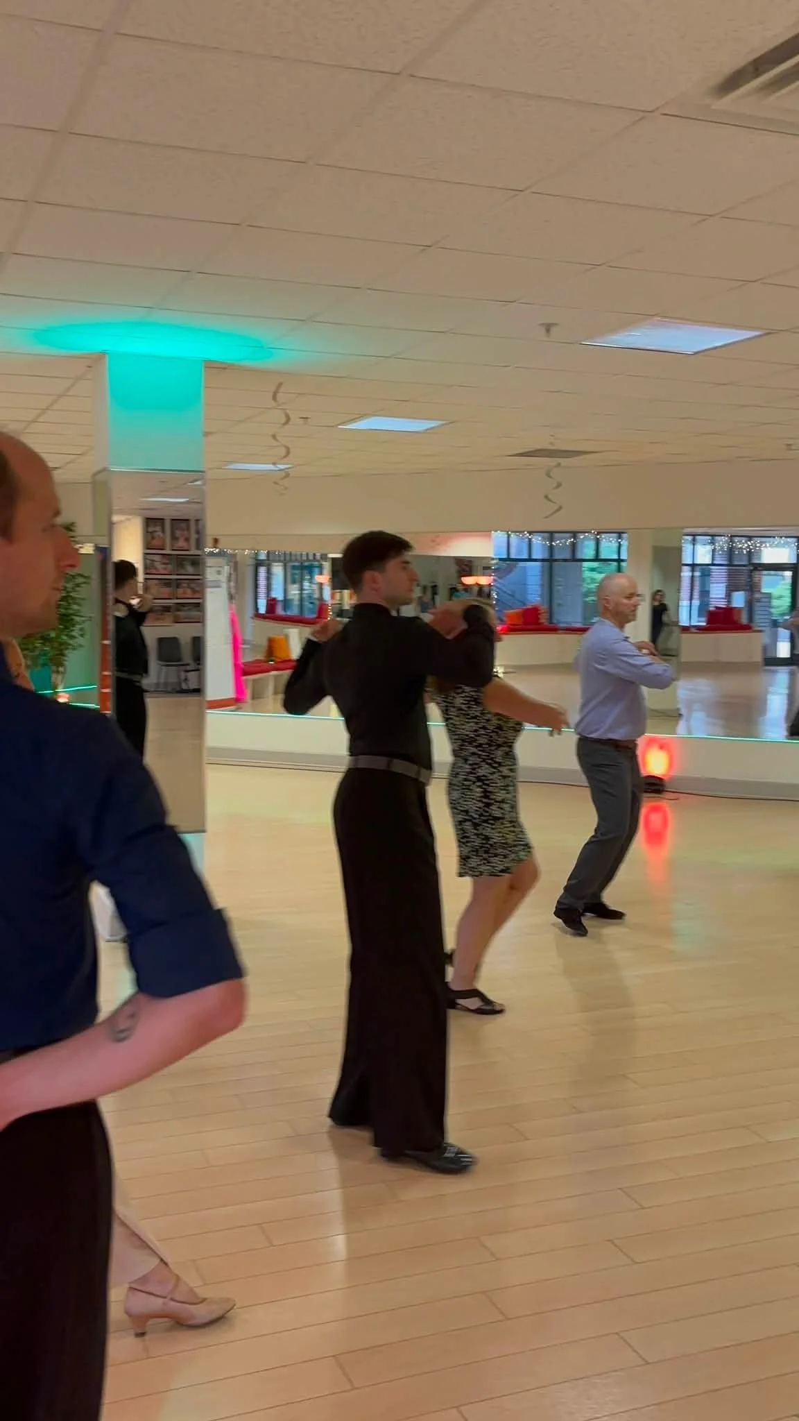 Class participants practice leading and following across the studio floor