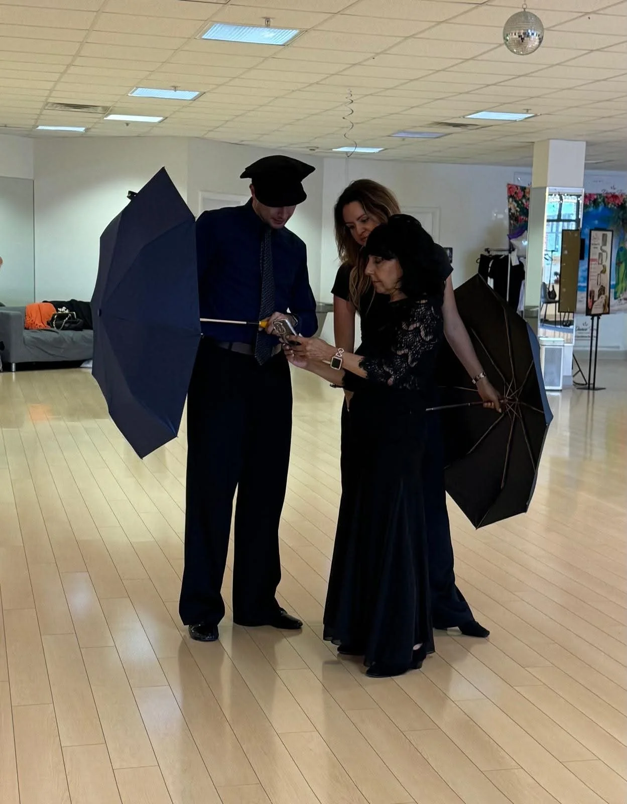 Two participants share a playful umbrella pose during the studio visit