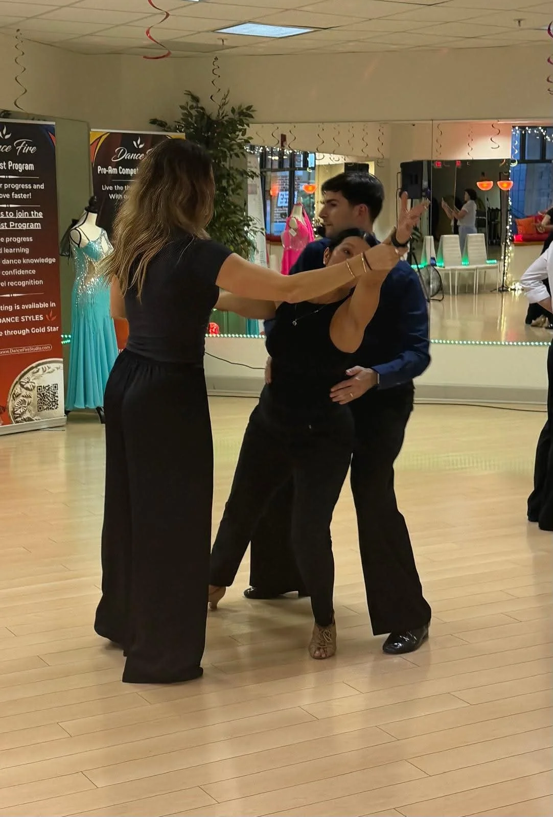 Two dancers work on their partnered hold during coaching