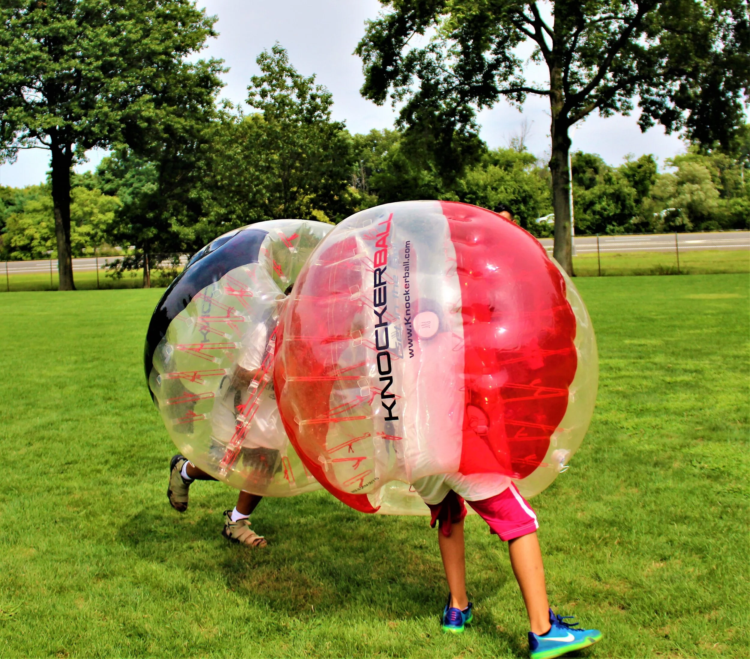Two players wearing Knockerballs bumping in a ring during a sumo-style game
