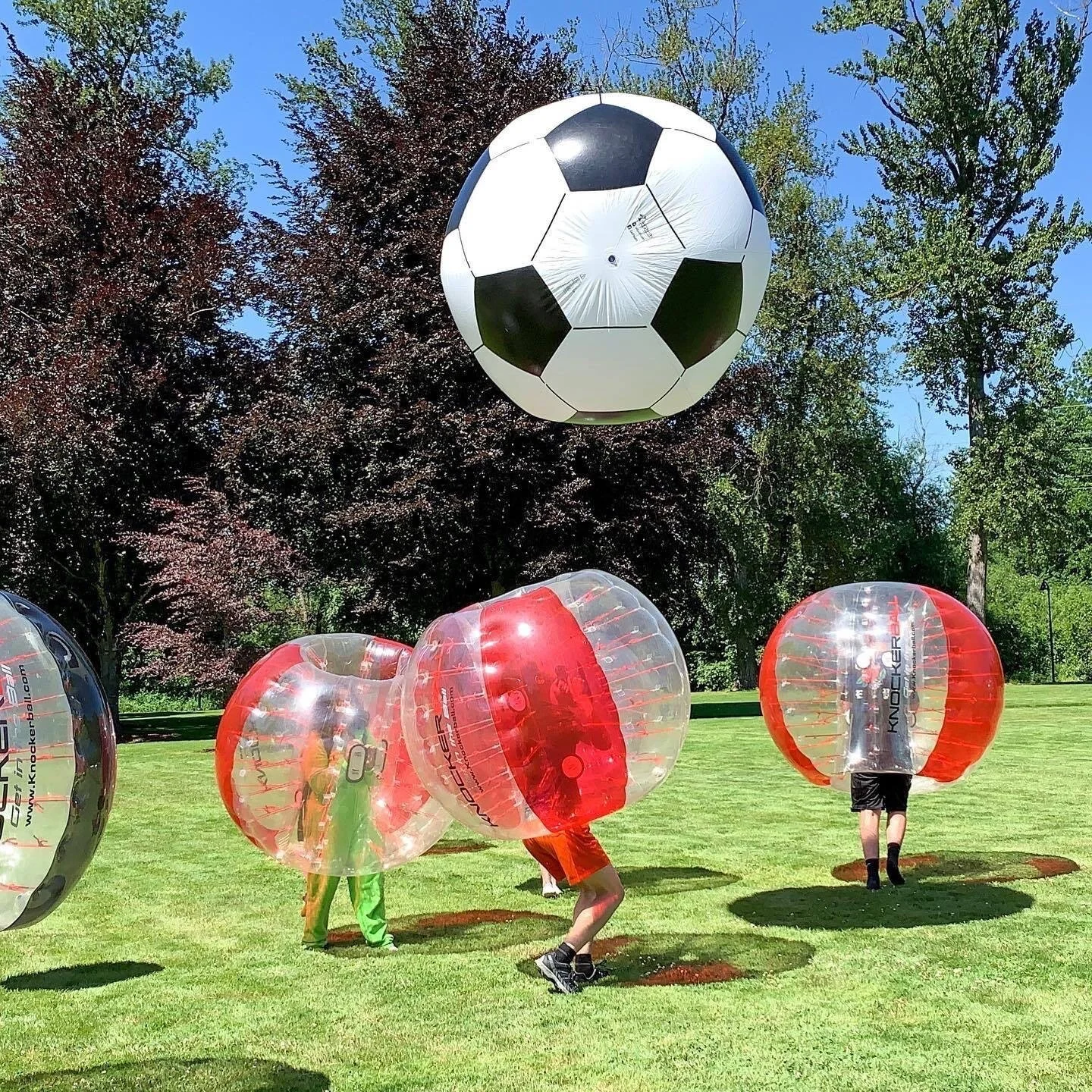 Players in Knockerballs playing a 3v3 soccer match, colliding mid-action