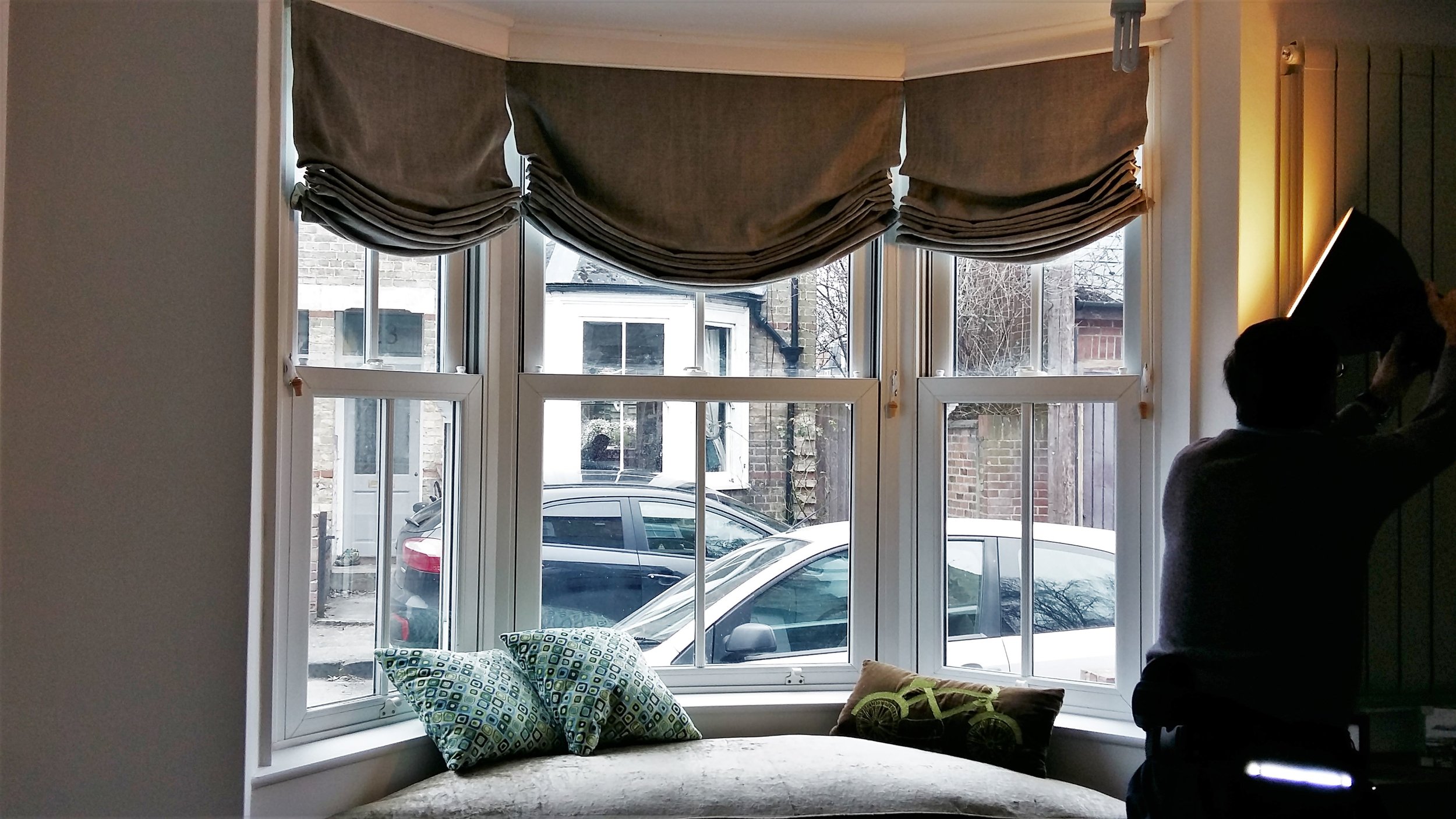 Draped Roman blind in a bay window
