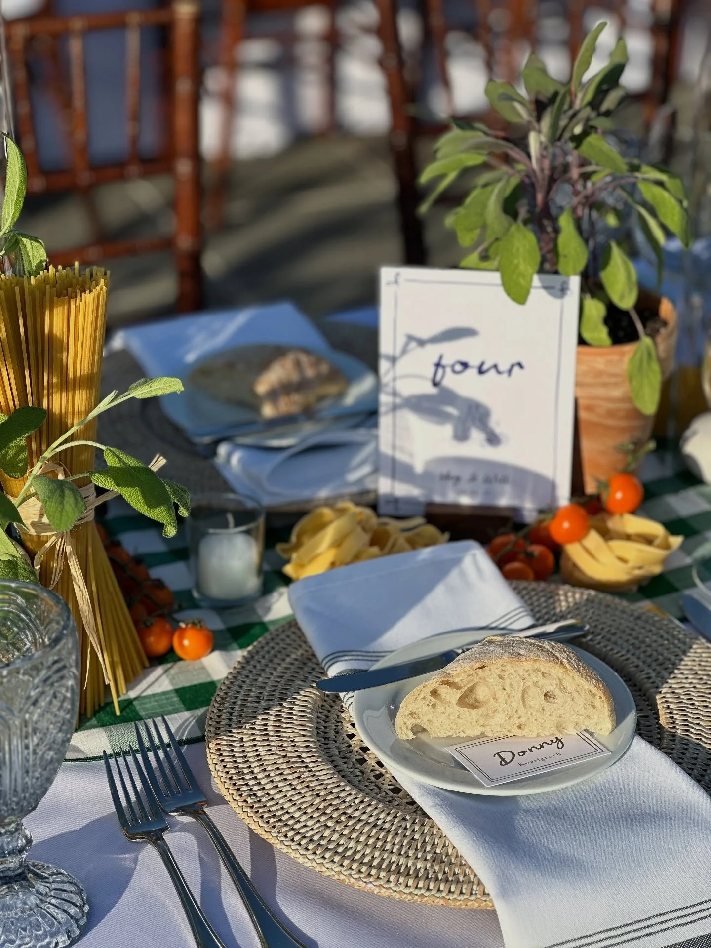the long tables were styled with potted herbs, piles of pasta, tomatoes on the vine, and darling place cards tucked under a slice of ciabatta. we wanted an Italian family dinner feel for this alfresco rehearsal dinner and the setting @conwayfarmsgolf