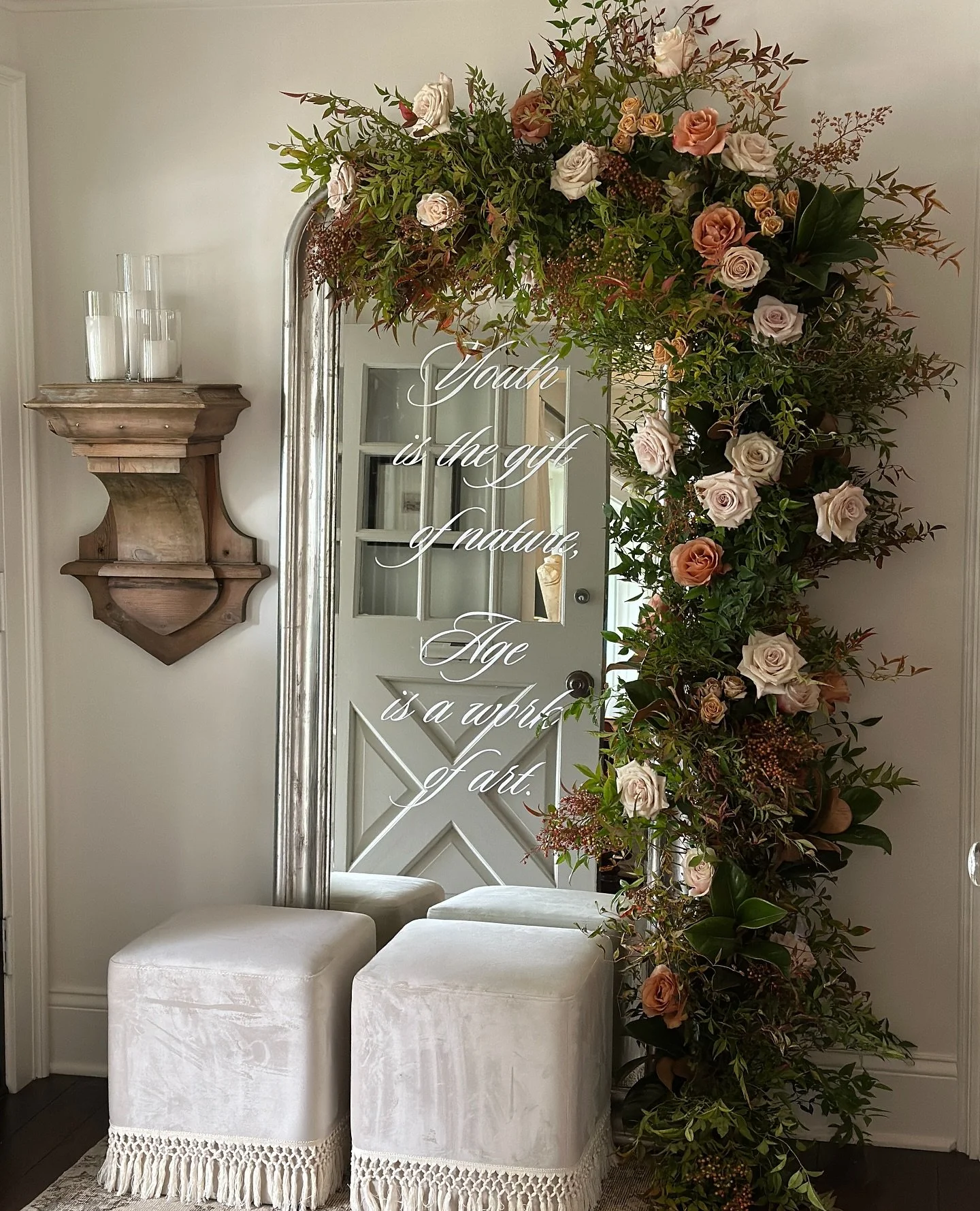a welcome installation marks the occasion, dresses up the foyer and makes an instant photo op. we used a quote on the mirror and @itstheflowerhouse embellished the frame. stunning vignette! 
#selfiemirror #floralinstallation #eventstylist #chicagoev