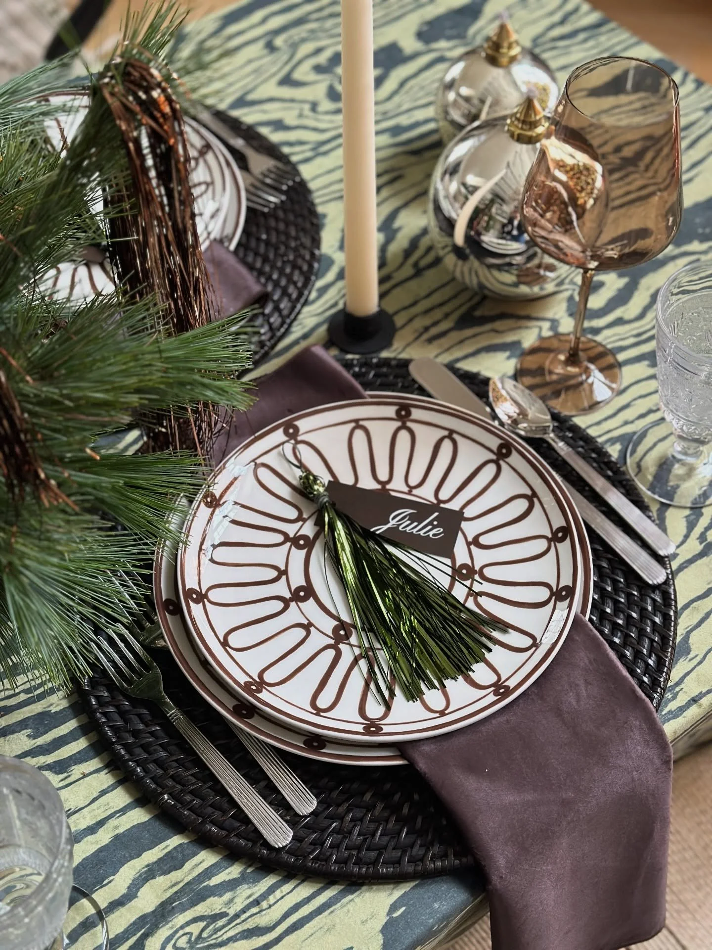 we got playful with this holiday party tablescape. the faux bois inspired linen in two tone green velvet set the scene for a brown patterned plate, sexy smoky wine glass and earthy napkin. we chose greenery for the table kissed with brown and gold ti
