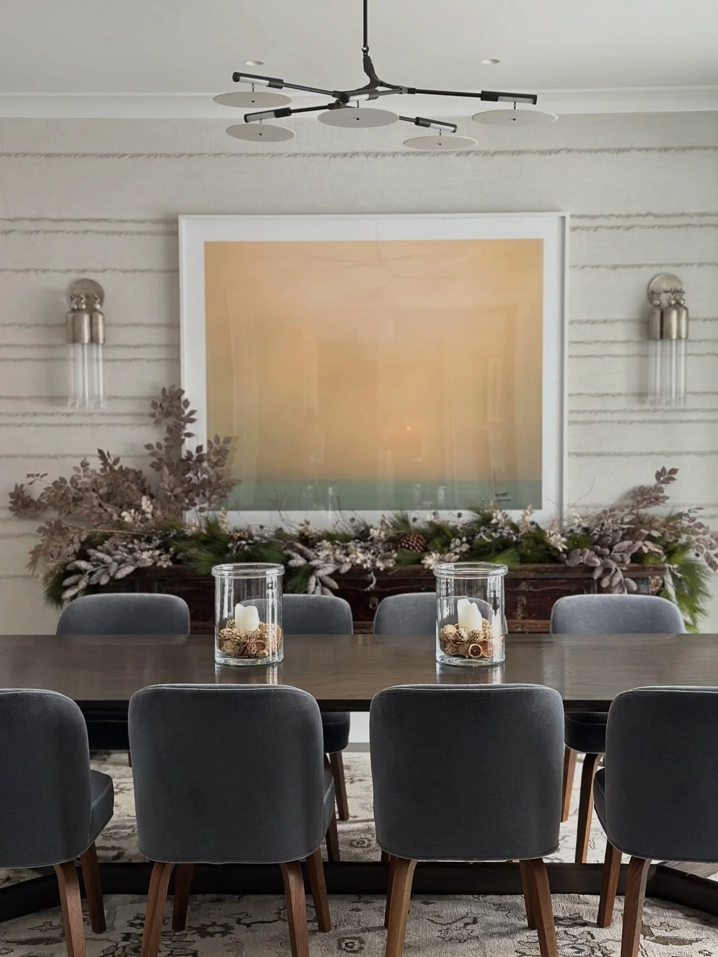 this homes Christmas decor stays neutral and organic. we incorporated this moment in the sideboard, using pine garland, pine cones and glittery brown sprigs of burrs and leaves. the rest of the accessories are simple greens in vessels, orange slices 