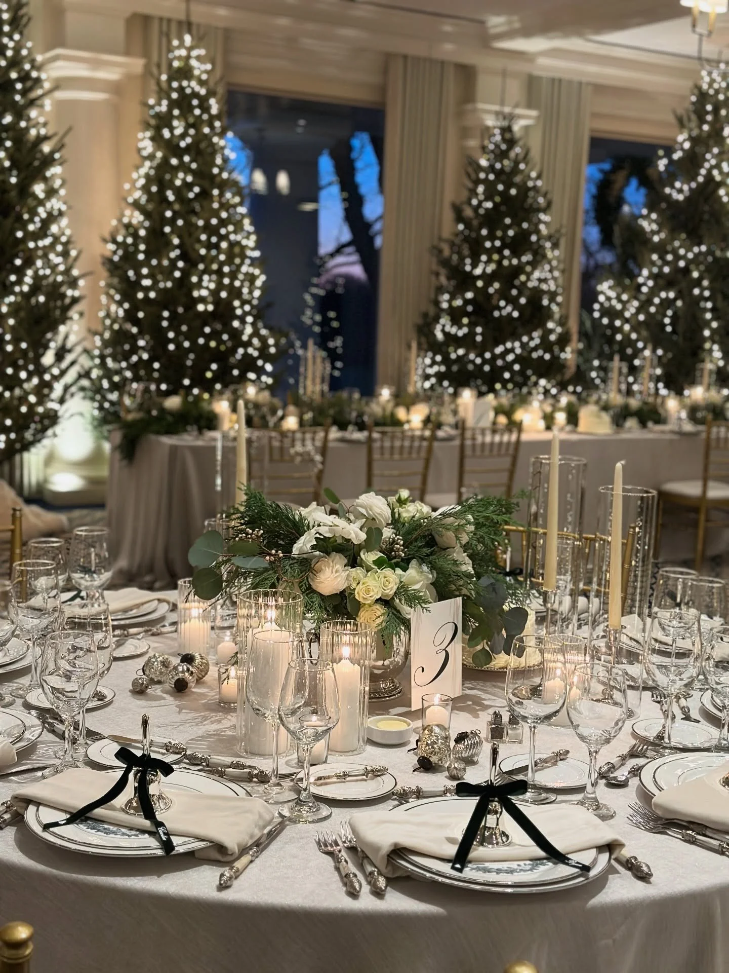 white Christmas wedding &hellip; our couple wanted a classic feel with all the details. we brought in 14 frasier fir trees and dotted them around the dining room. tables were decorated with white and greenery florals, individual cakes, and a kiss of 
