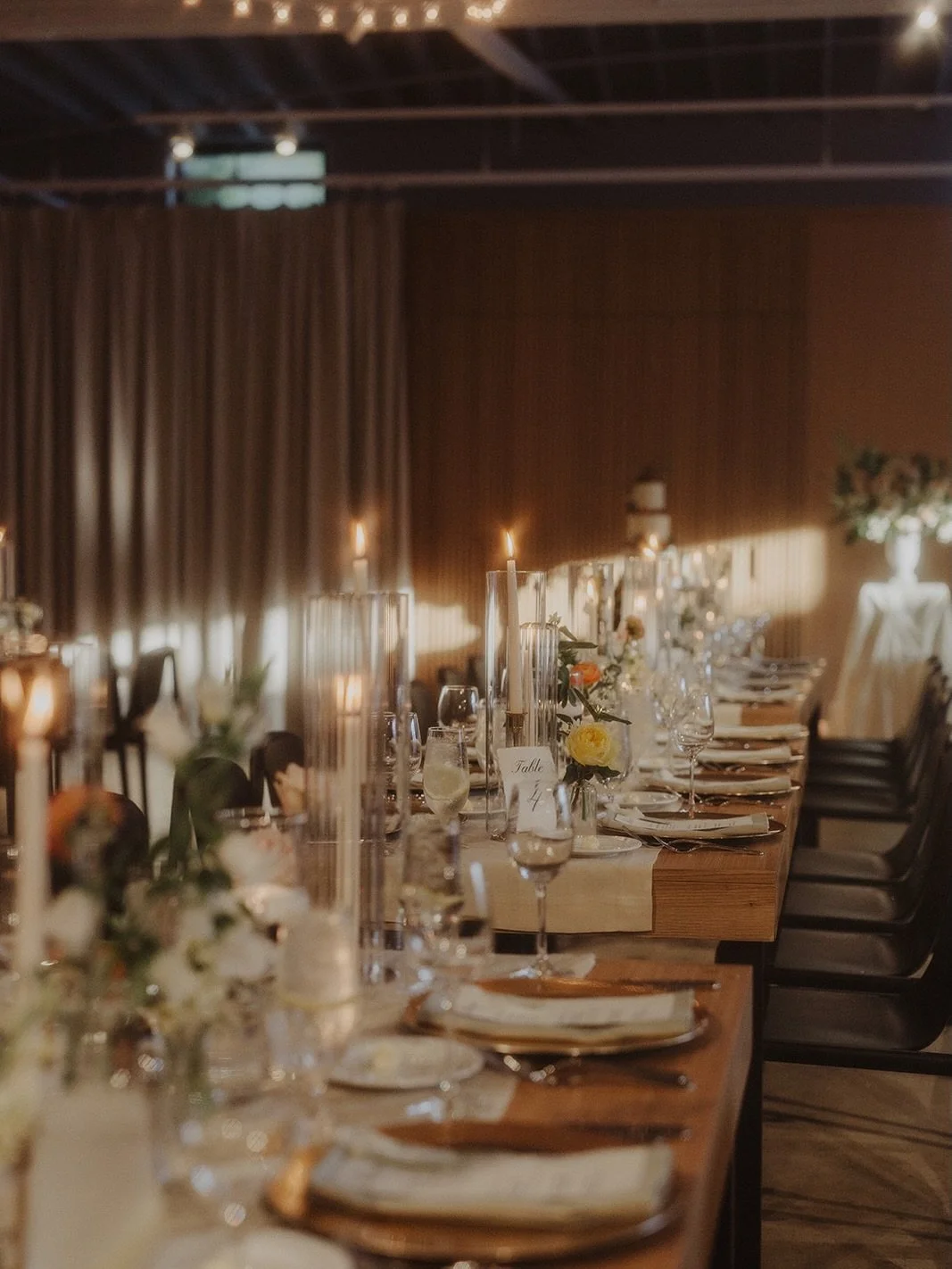 we flipped the ceremony space and set the tables for dinner, under bistro lights and a chic backdrop. 

we used budvases and taper candles on the tabletop, beautiful menu cards with torn edges. 

the head table was surrounded by their ceremony floral