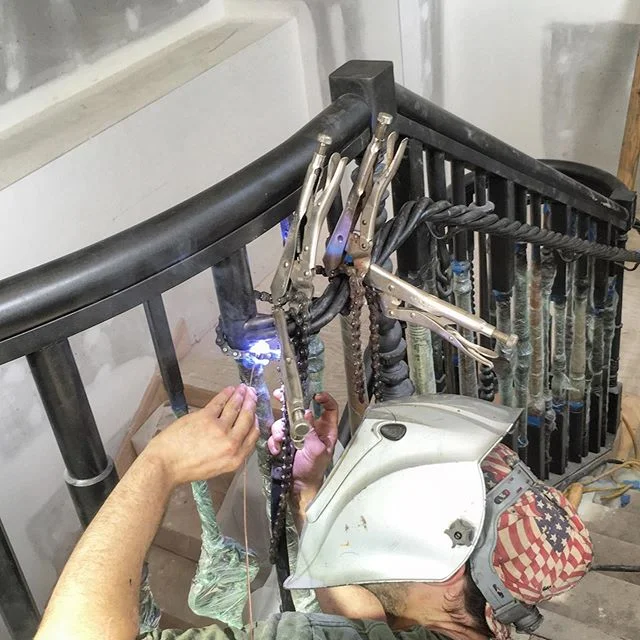 Chain clamps and overhead TIG welds - all part of the fun of fitting up this twisted handrail. Getting close! 🔩🗜#metalfabrication #tigwelding #designbuild