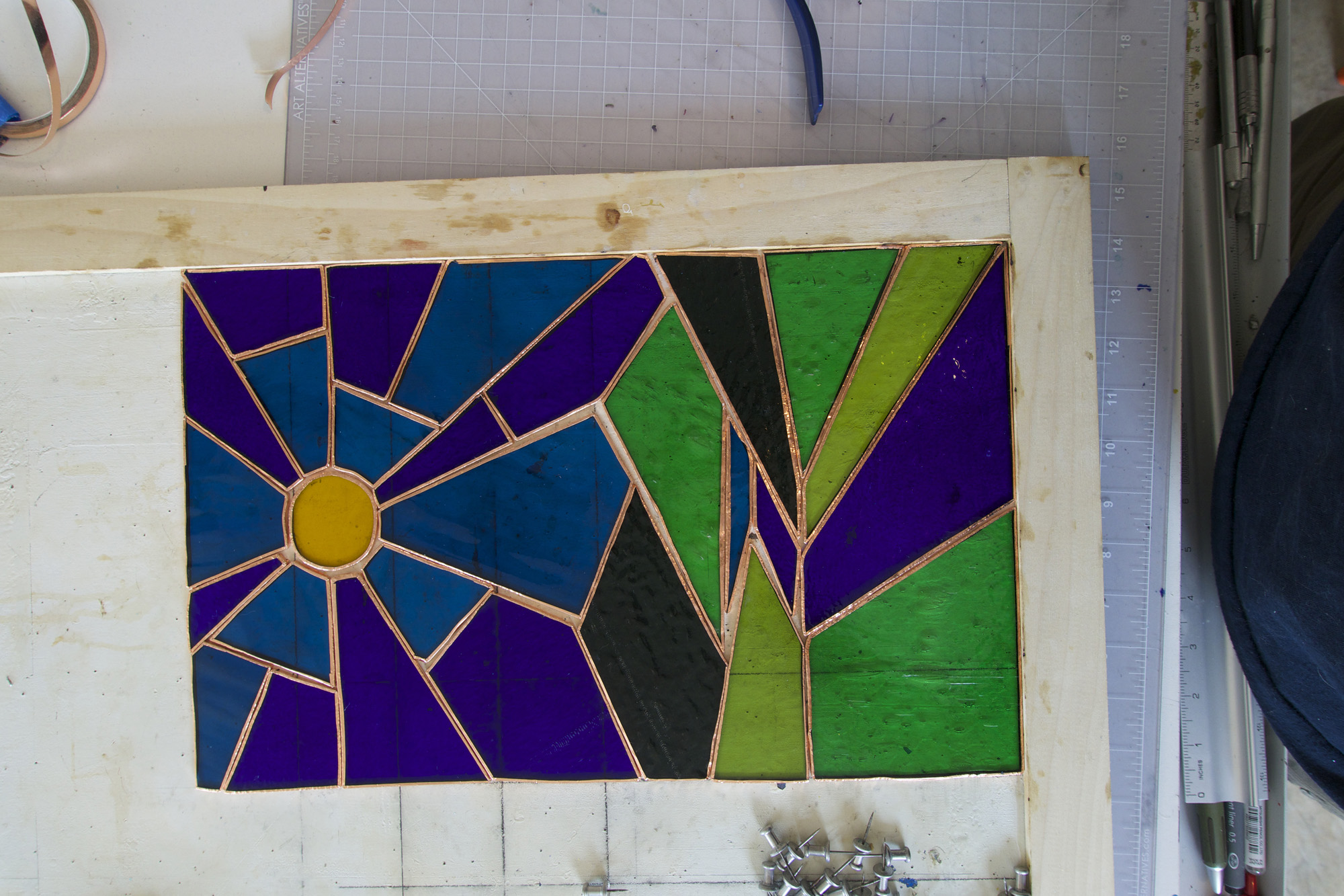 The outside edges of each piece are wrapped in a copper tape with adhesive and then burnished into place. I lost a bit of the alignment in the middle.