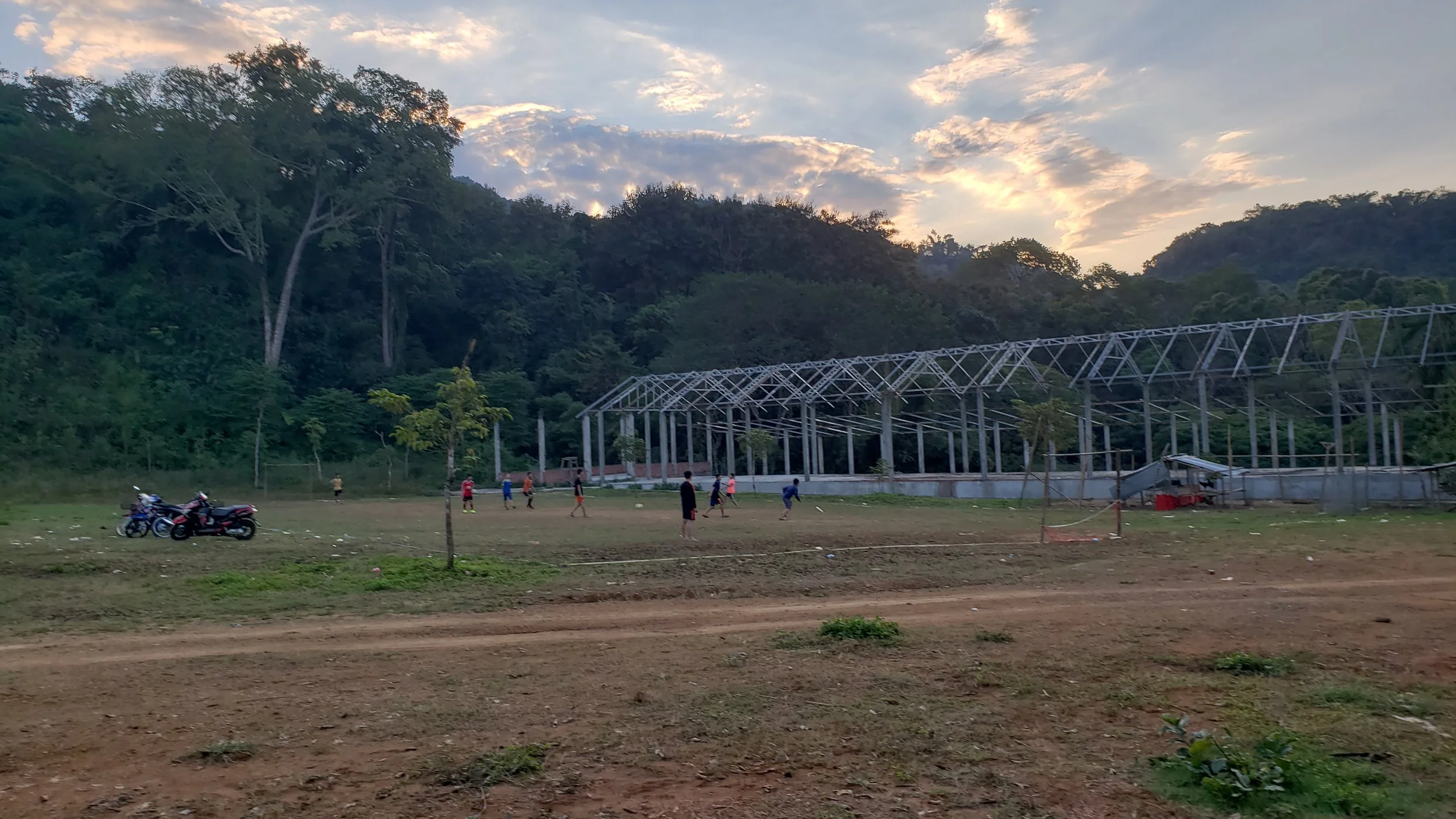 Local kids play soccer and try to throw our frisbee as the sun sets.
