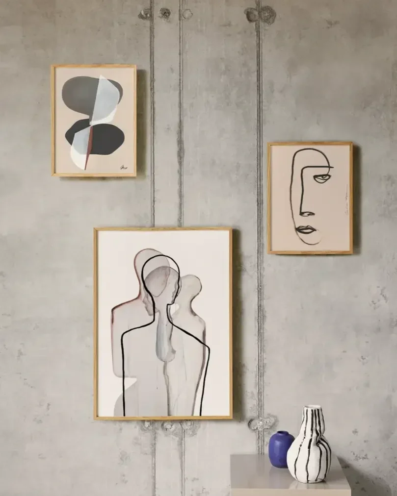 Paper Collective Scandinavian art prints in oak frames styled with handcrafted ceramic vases in a minimalist Nordic interior.